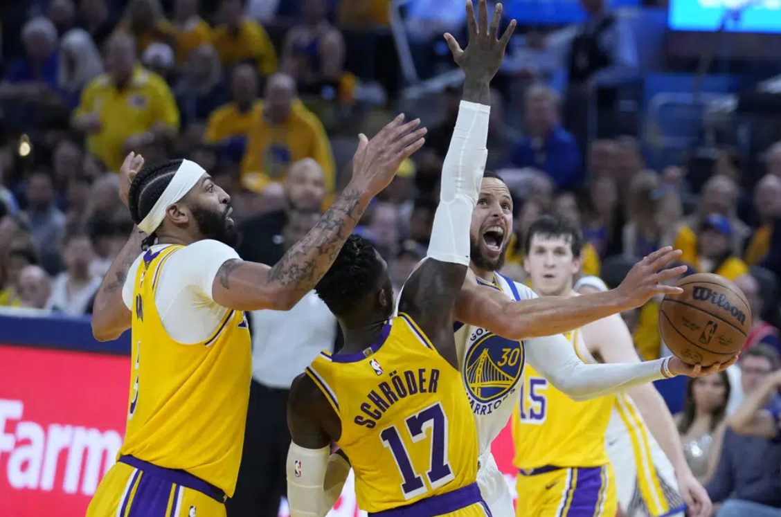 Golden State Warriors guard Stephen Curry (30) shoots against Los Angeles Lakers forward Anthony Davis, left, and guard Dennis Schroder (17) during the second half of Game 5 of an NBA basketball second-round playoff series Wednesday, May 10, 2023, in San Francisco.