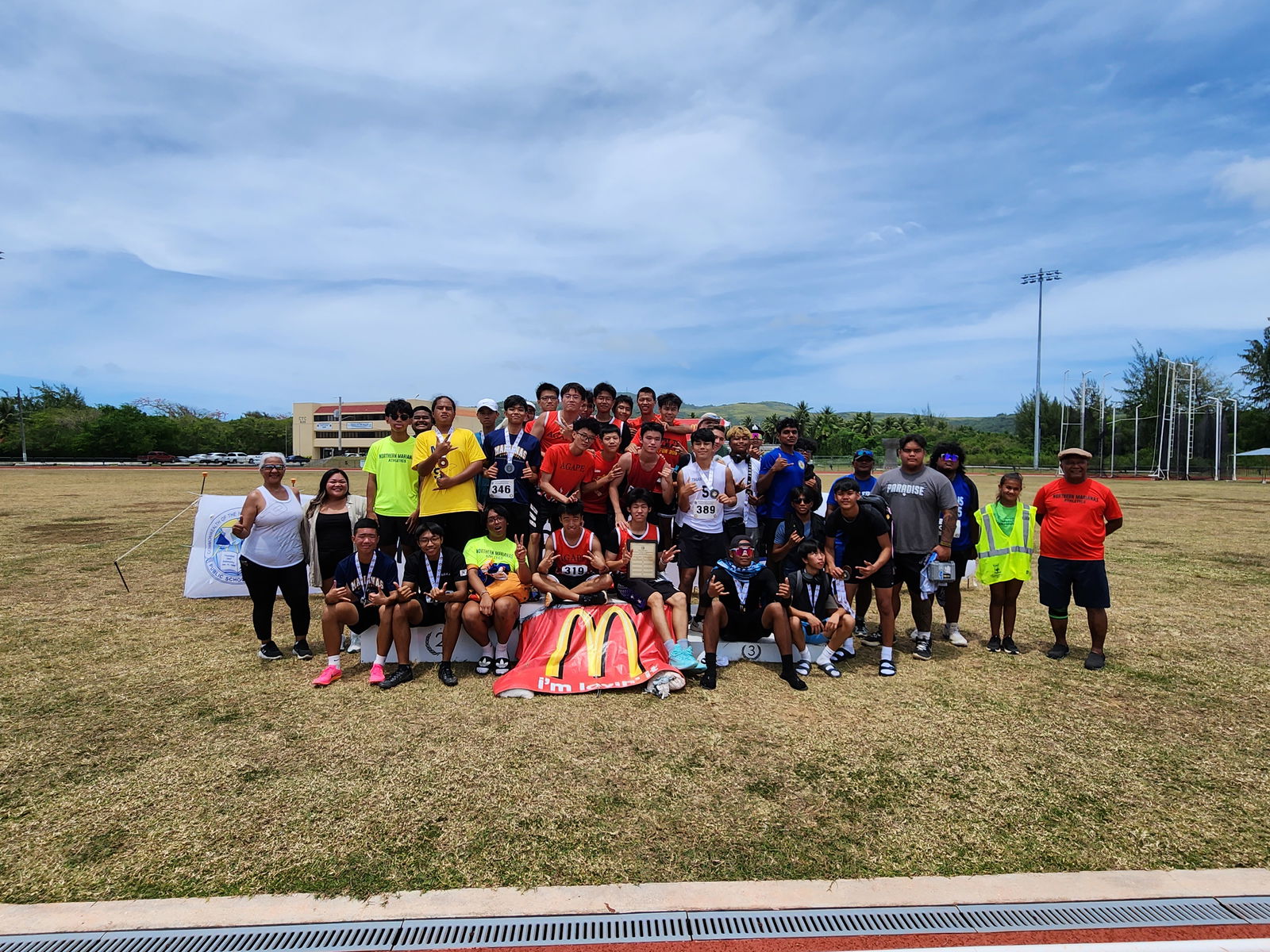 Agape Christian School, Marianas High School, and Tinian Jr/Sr High School male athletes pose for a photo with Northern Marianas Athletics President Ray Tebuteb, right, during the awards ceremony for the U18 boys high school division of the PSS-McDonald’s All School Athletics Championships at the Oleai Sports Complex on Saturday.