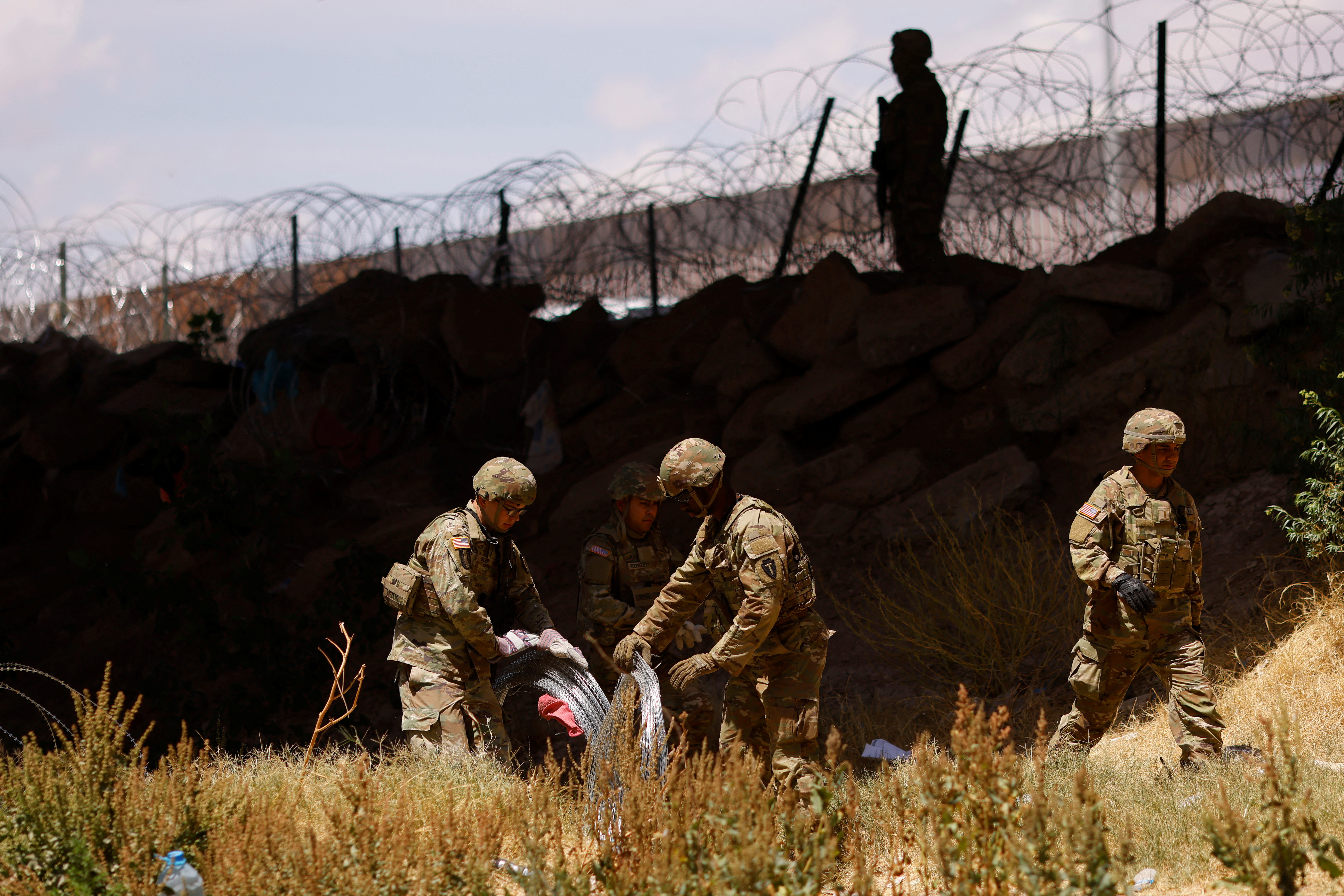 Members of the Texas Army National Guard extend razor wire to inhibit migrants from crossing, as seen from Ciudad Juarez, Mexico May 13, 2023. REUTERS/Jose Luis Gonzalez