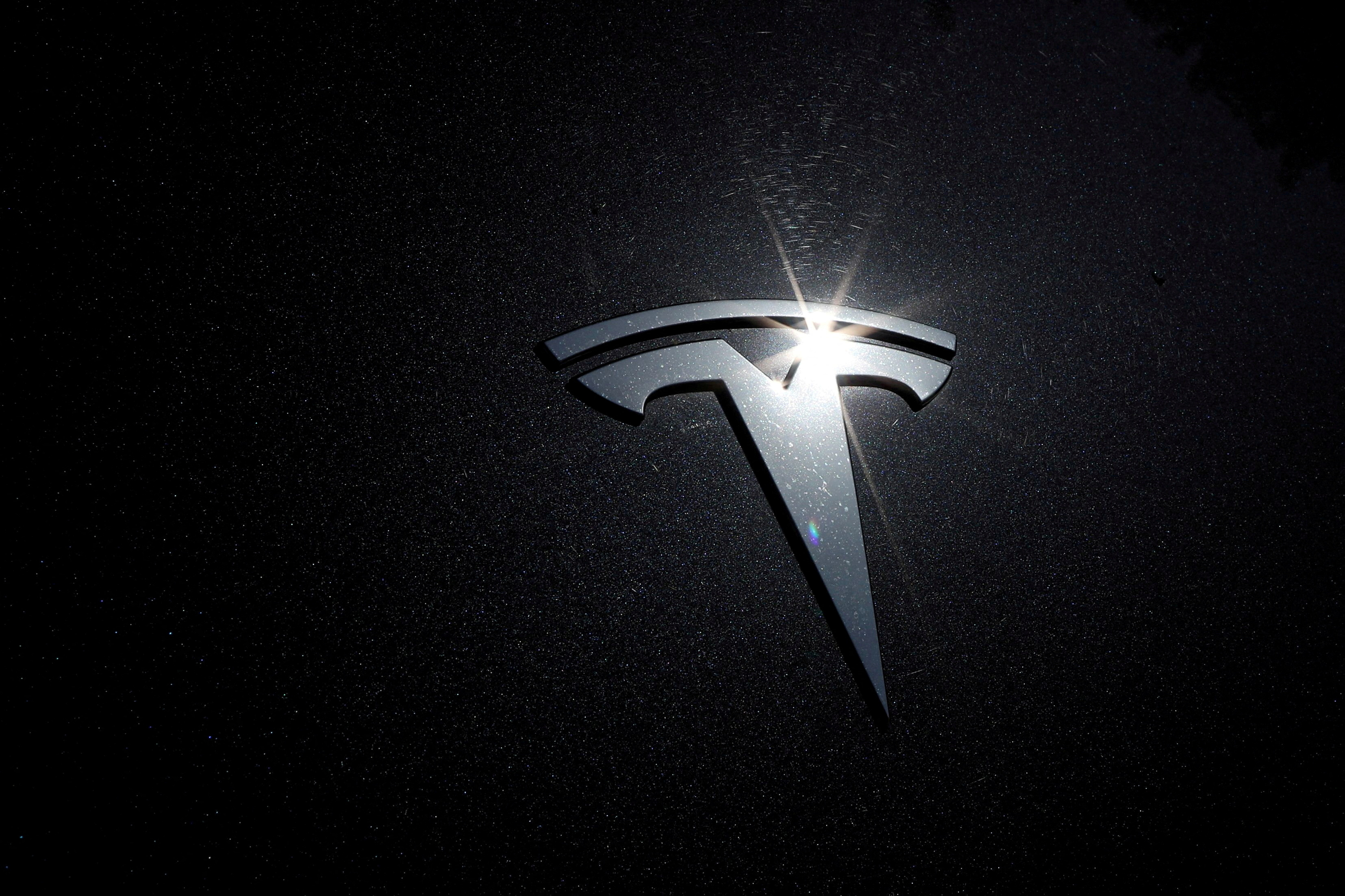FILE PHOTO: The Tesla logo is seen on a car in Los Angeles, California, U.S., July 9, 2020. REUTERS/Lucy Nicholson/File Photo