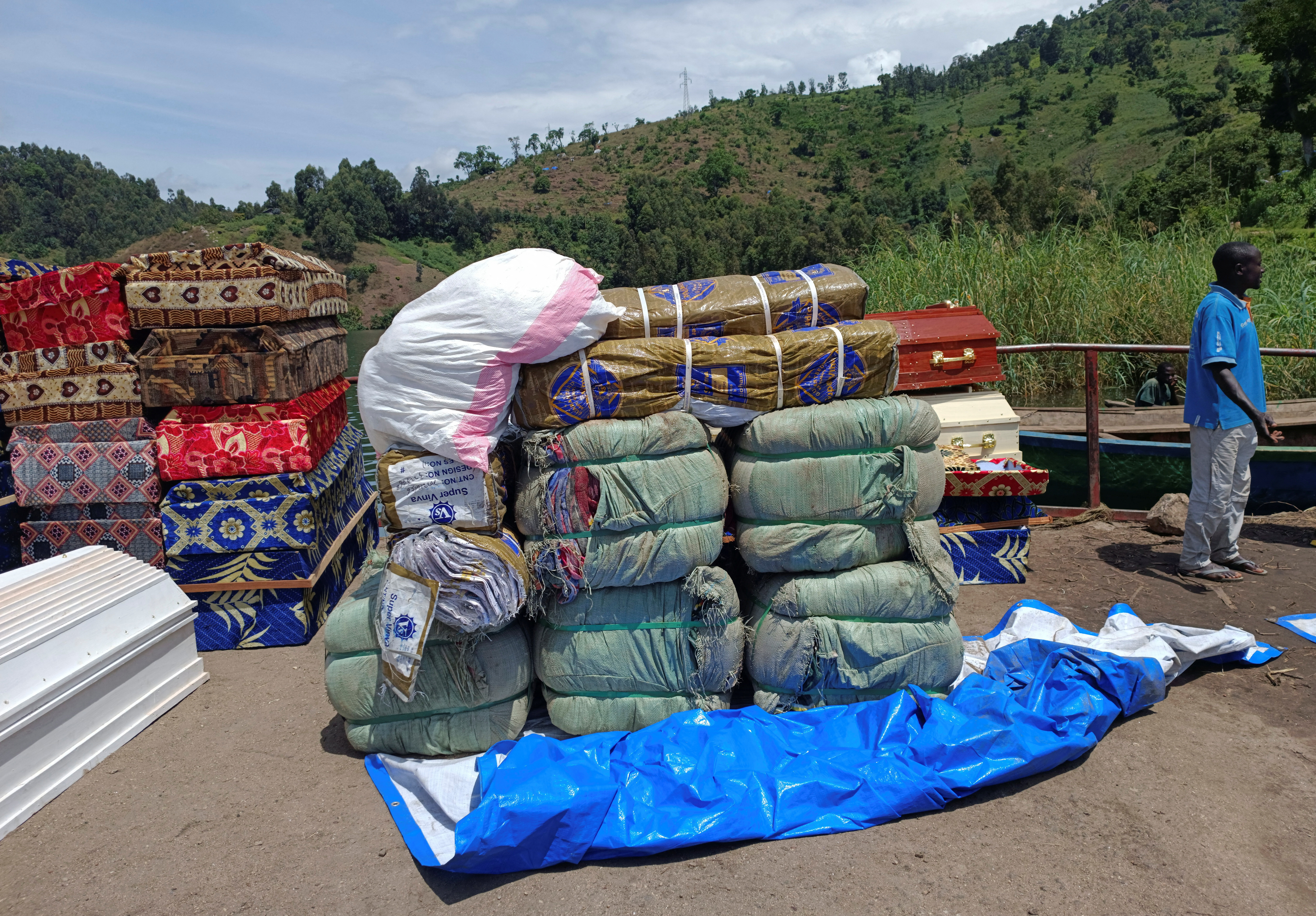 Workers arrange humanitarian relief and coffins for the Congolese civilians killed following rains that destroyed the remote, mountainous area and ripped through the riverside villages of Nyamukubi, Kalehe territory in South Kivu province of the Democratic Republic of Congo May 9, 2023. REUTERS/Djaffar Sabiti