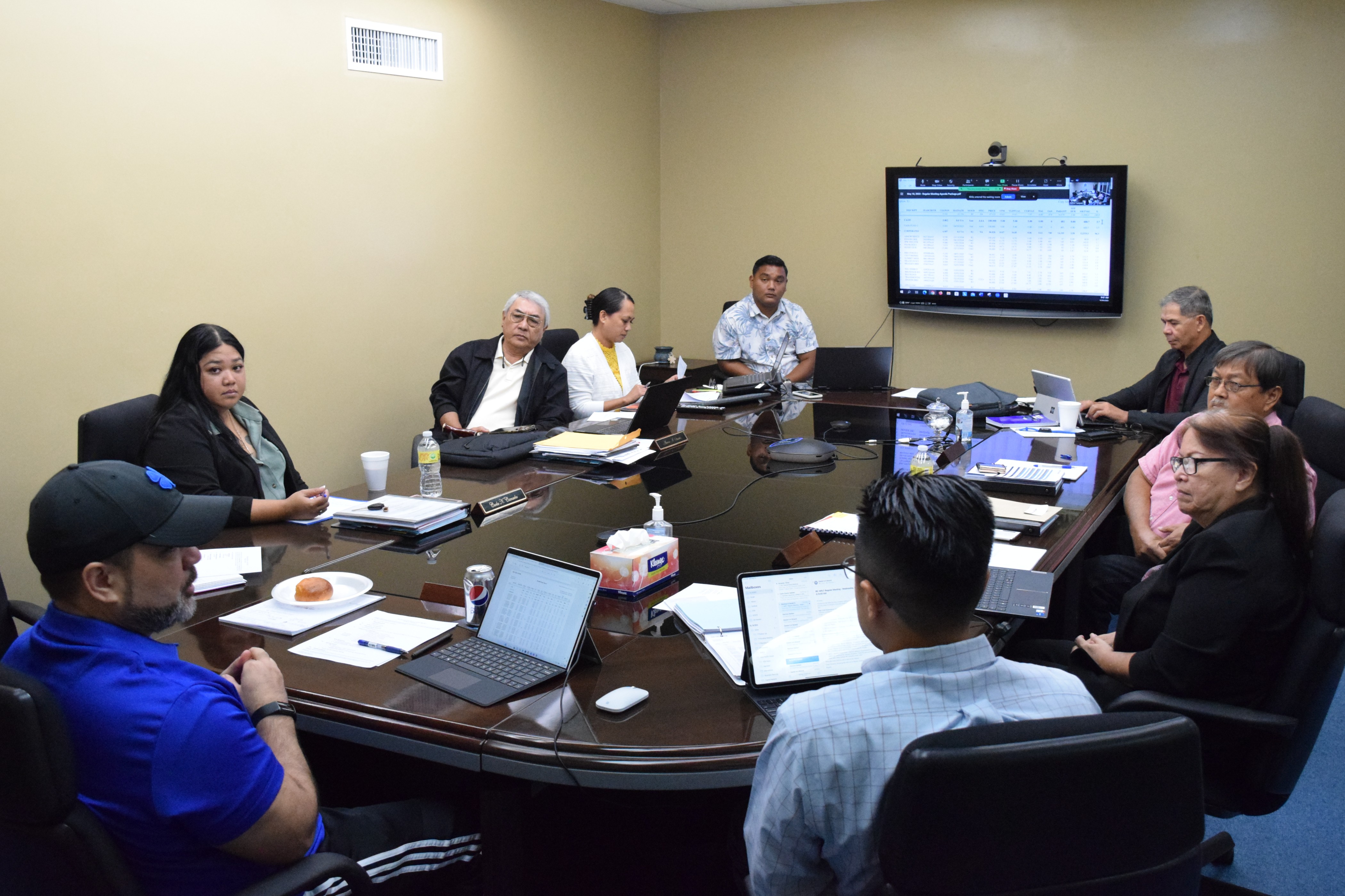 Newly elected Marianas Public Land Trust Chairman Philip Mendiola-Long left, speaks, as vice chair Dr. Rita A. Sablan, right, treasurer Alvaro Santos, third left, members Carla Camacho, second left, and Vianney Hocog, second right, listen. Also in the photo are financial officer Vinney A. Hocog, center background, legal counsel Robert T. Torres, right background, and Raymond James & Associates representative Jason Miyashita, back to the camera.
