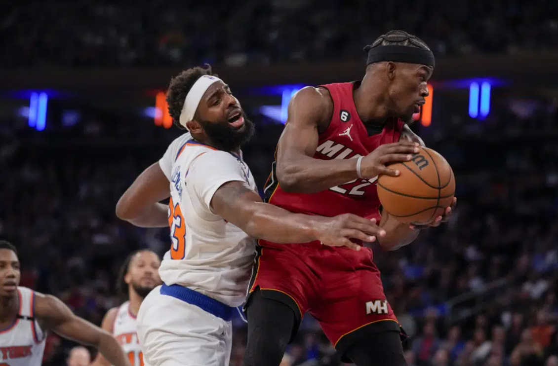 Miami Heat forward Jimmy Butler (22) rebounds against New York Knicks center Mitchell Robinson (23) during the first half of Game 1 in the NBA basketball Eastern Conference semifinals playoff series, Sunday, April 30, 2023, in New York.