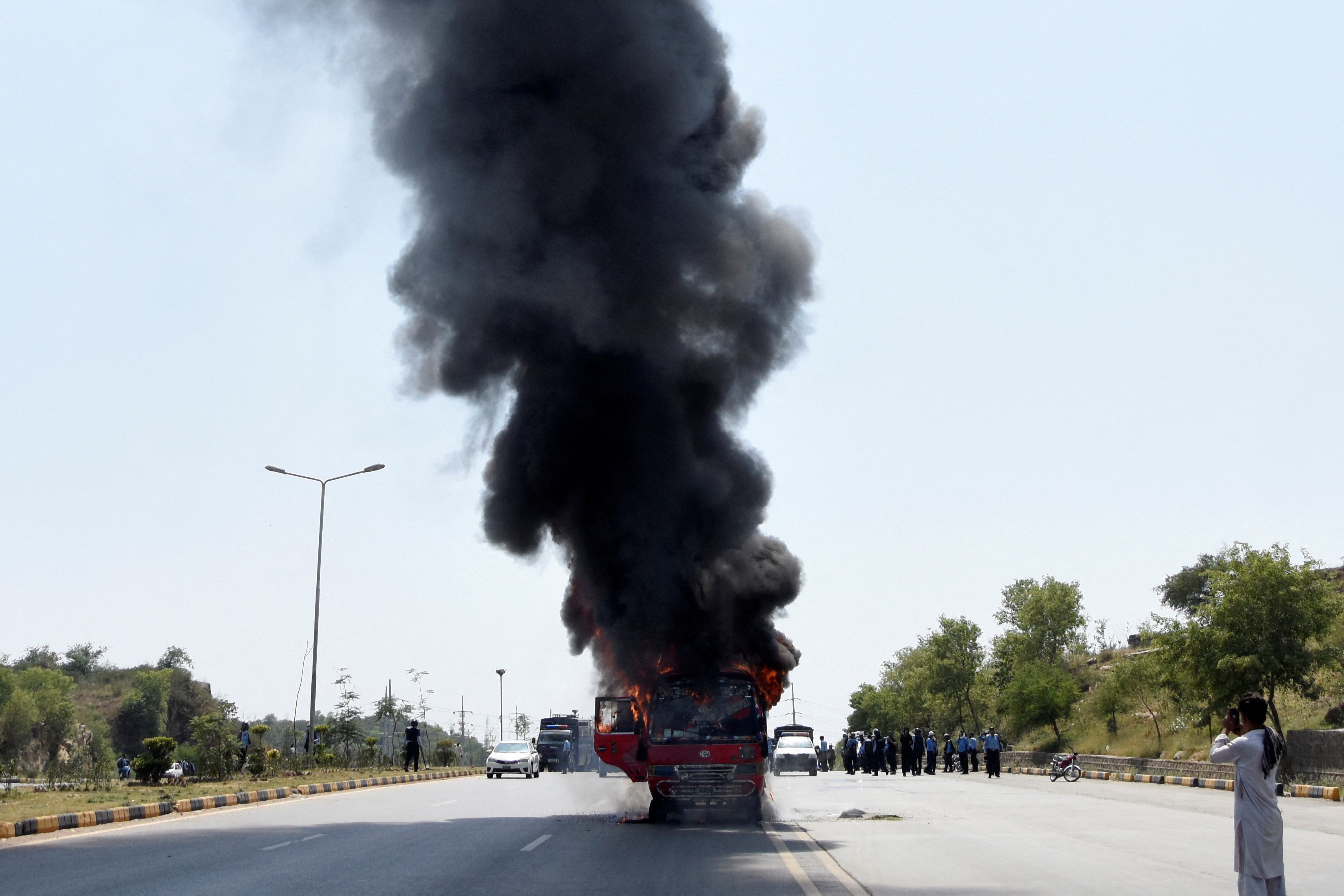 Fire and smoke billows from a bus after it caught a fire during clashes between police and supporters of Pakistan's former Prime Minister Imran Khan in Islamabad, Pakistan, May 12, 2023. REUTERS/Stringer NO RESALES. NO ARCHIVES.