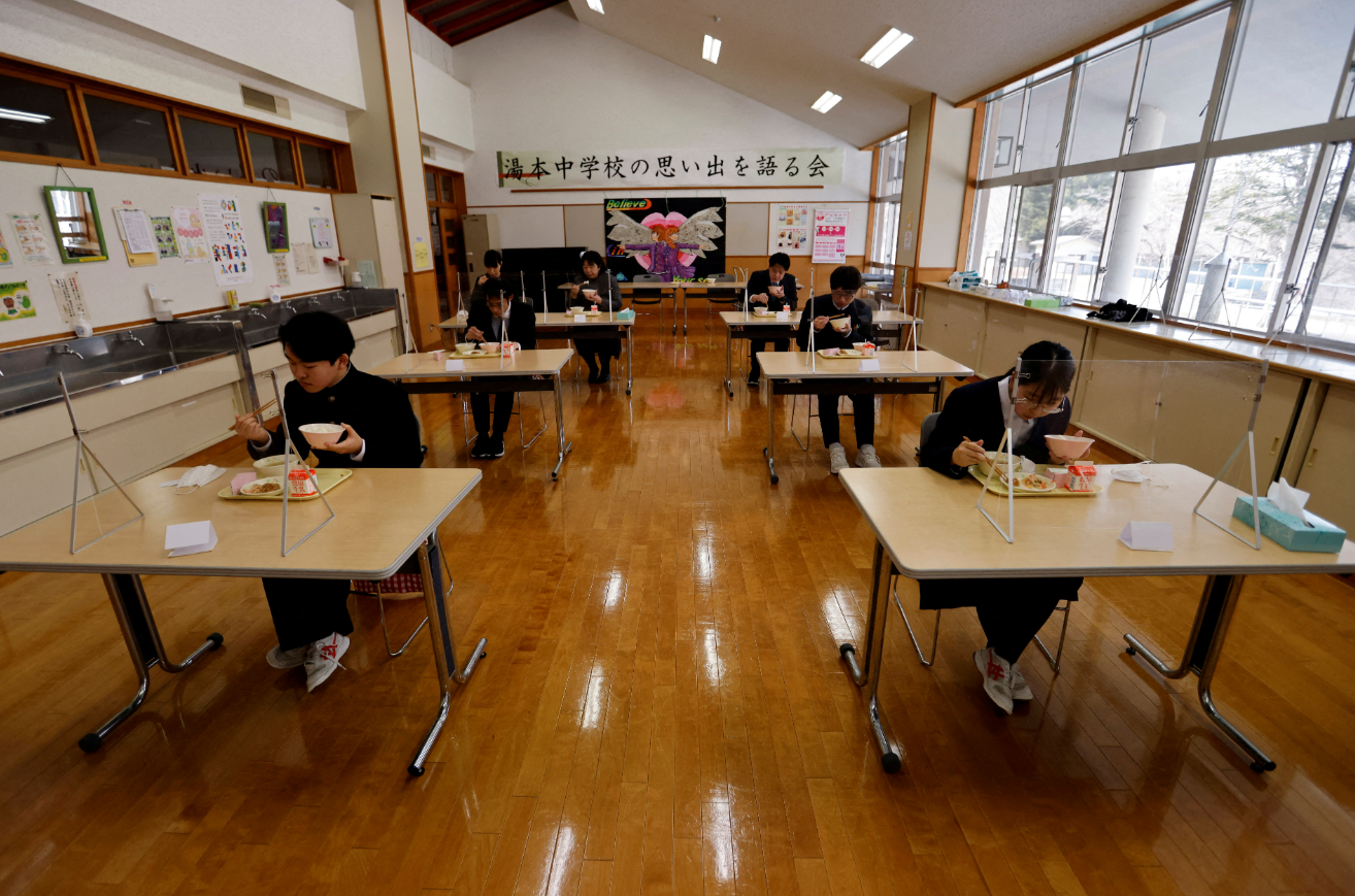 Eita Sato, 15, and Aoi Hoshi, 15, the only two students at Yumoto Junior High School, have their last school lunch with their teachers before their graduation and the institution's closing ceremony, Fukushima Prefecture, Japan, March 9, 2023.