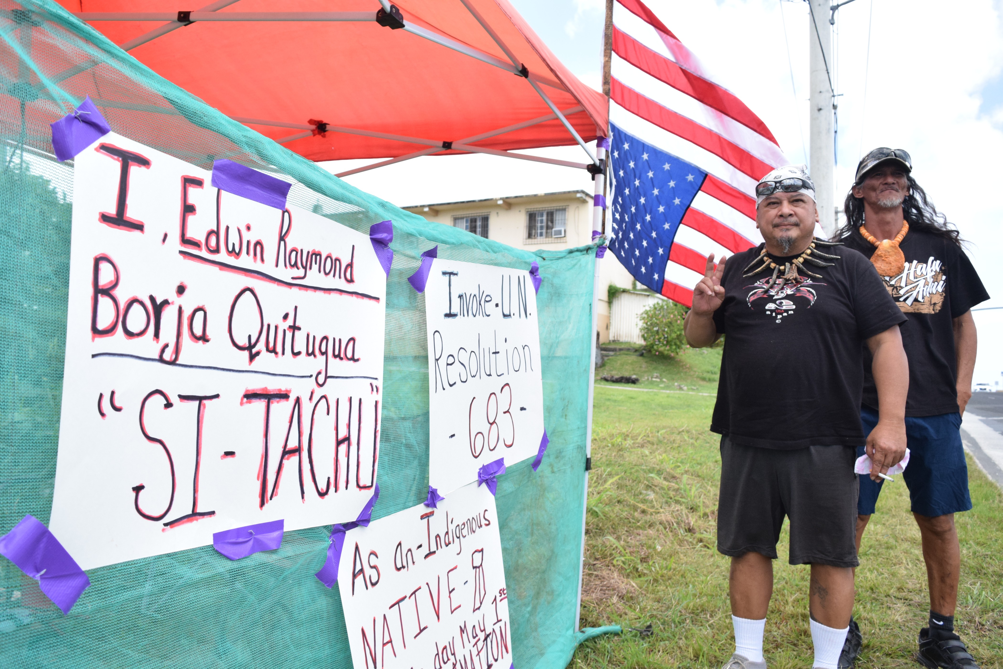 Raymond "Bo" Quitugua and Herman Tudela stage a protest action on Middle Road in Gualo Rai across from the United States Courthouse on May 1, 2023.