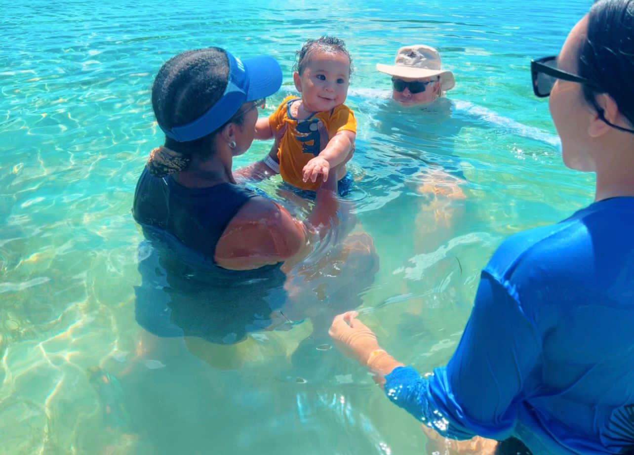Coaches Christina and Roy go over holding techniques with a parent during an aquatics class.