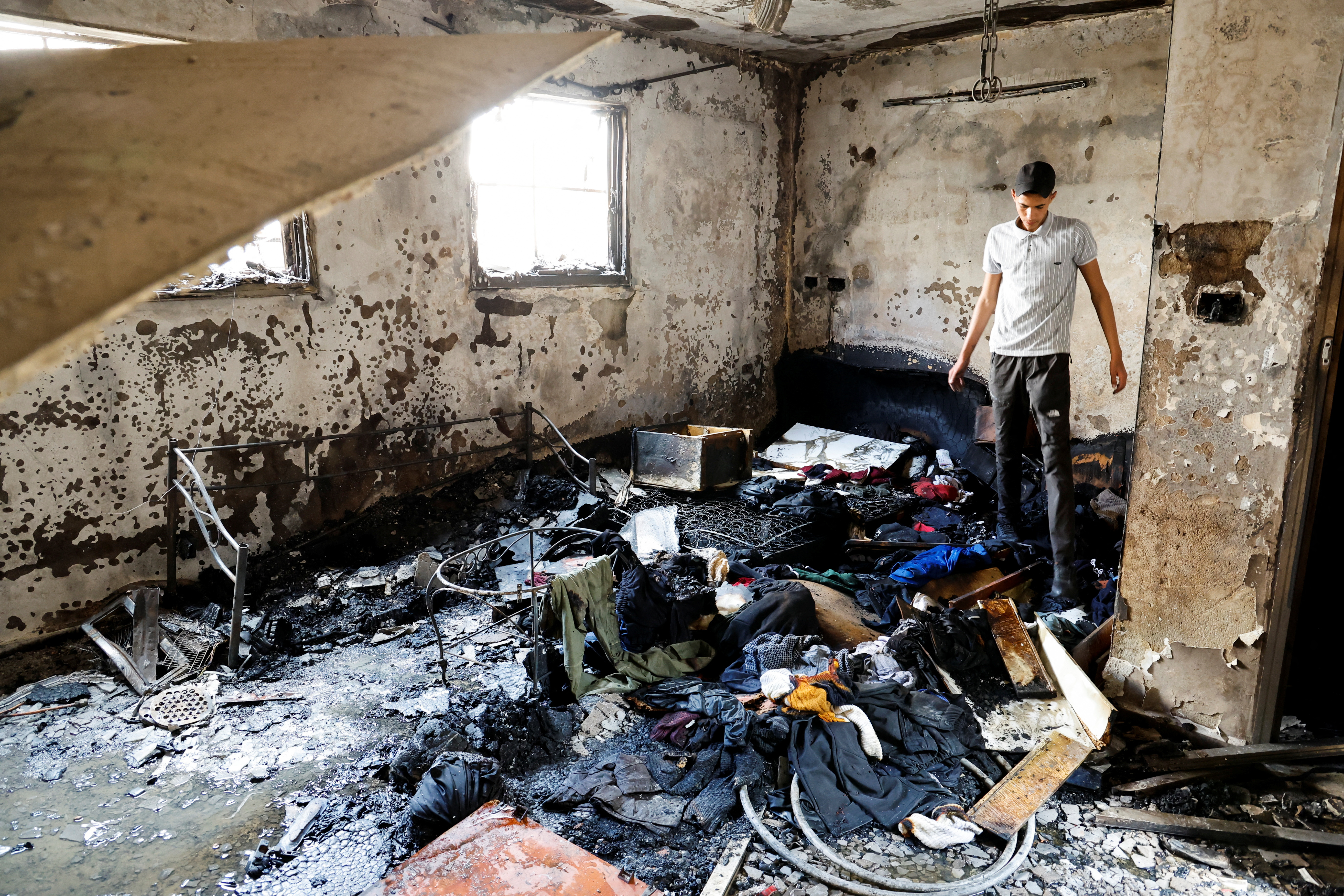 A man stands in a damaged building at the site of deadly Israeli raid in Balata camp in the Israeli-occupied West Bank May 13, 2023. REUTERS/Raneen Sawafta