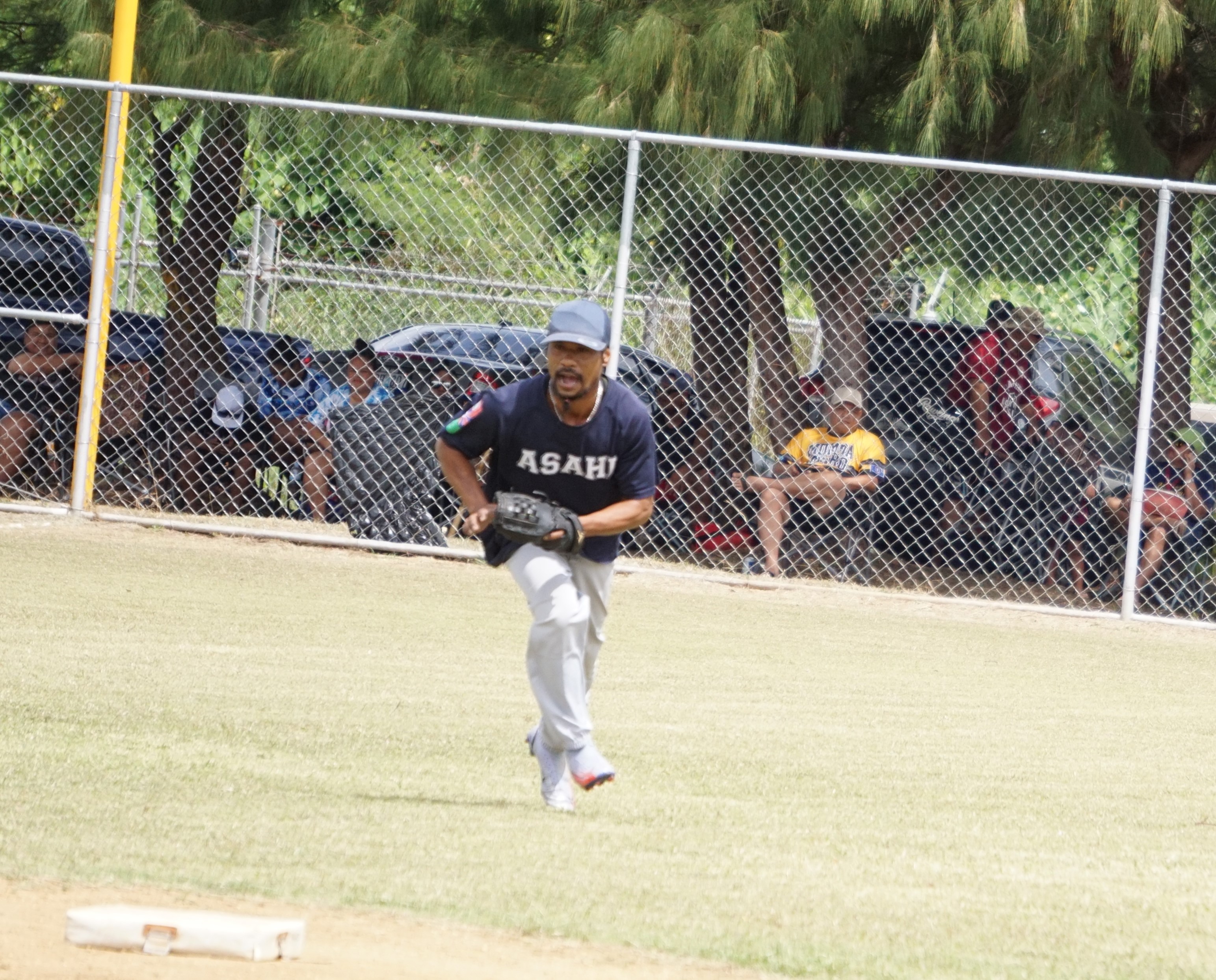 Asahi's Matsutaro looks on for the out after securing a grounder during a Budweiser Belau Amatuer Softball League game at the Dandan baseball field.