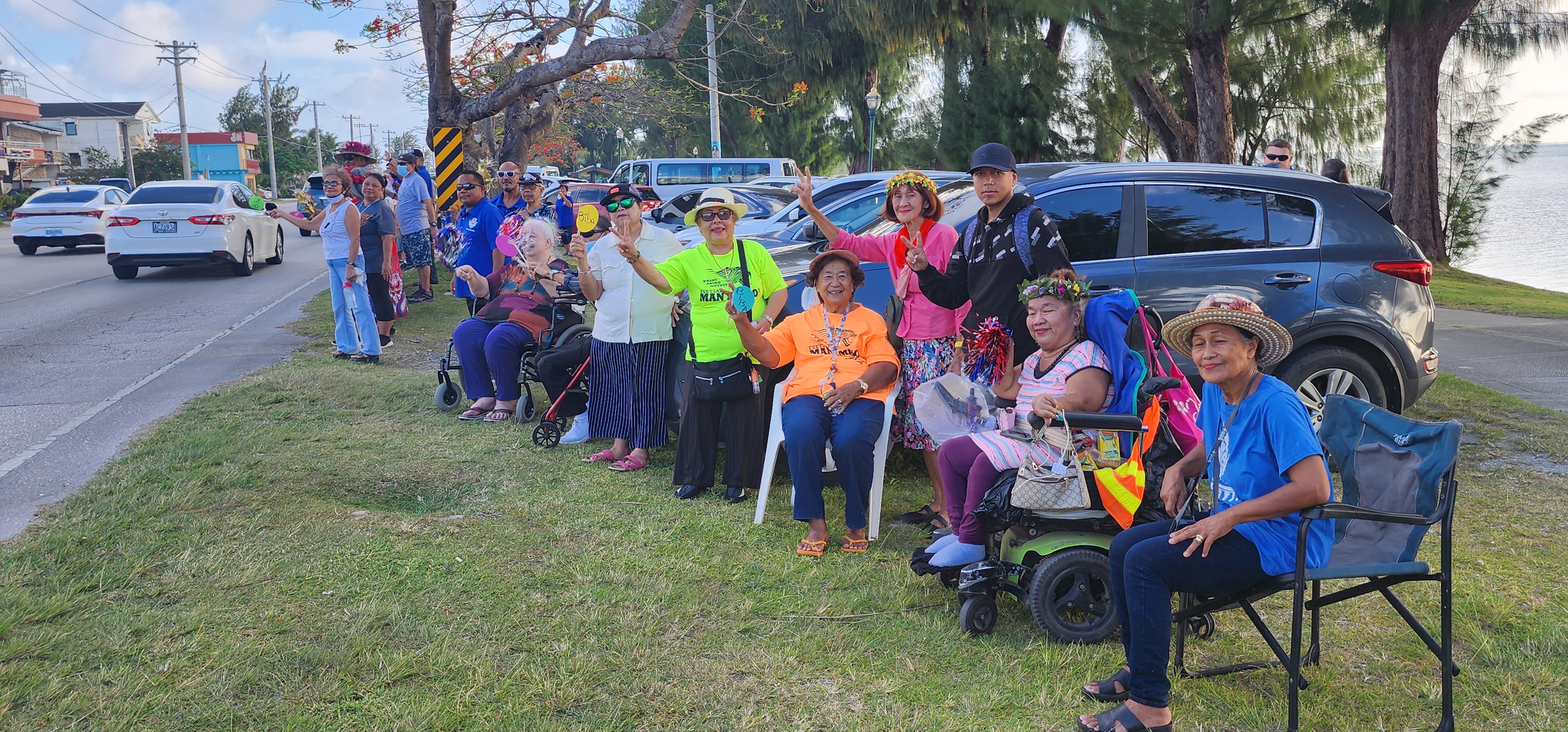 Senior citizens participate in a road-side waving activity on Beach Road in San Jose as part of the CNMI’s Older Americans Month celebration.