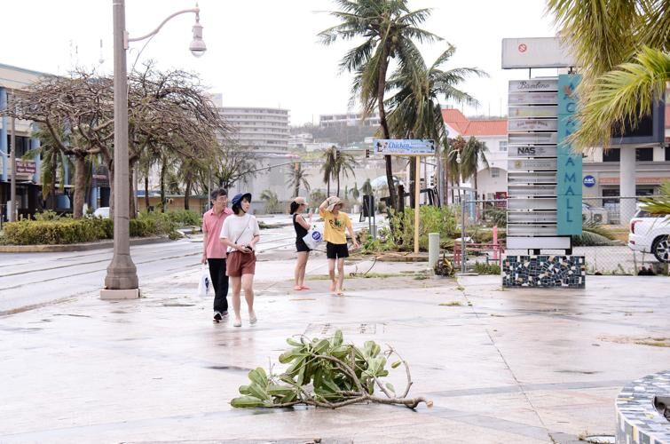 POST-STORM STROLL: Tourists walking through Tumon look at debris and damage in the aftermath of Typhoon Mawar Thursday. John O'Connor/The Guam Daily Post 