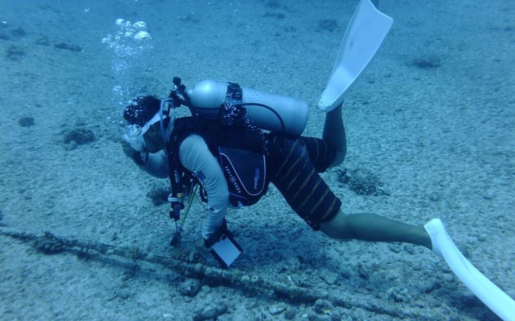 An IT&E diver checks an undersea fibre optic cable.
