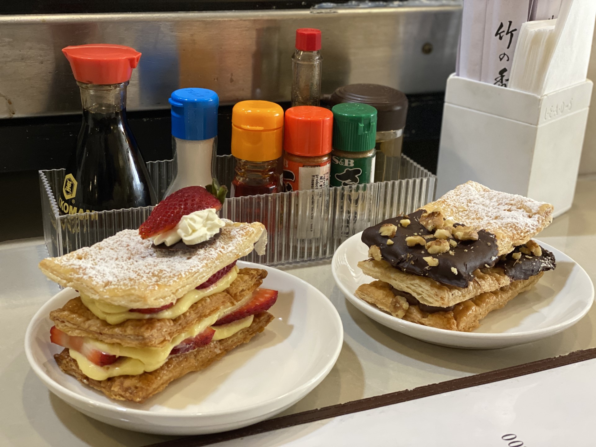 The strawberry mille feuille, left, has custard cream and sliced strawberries while the chocolate mille feuille features chocolate and walnuts. Both fillings come with a crispy pastry and are delicious.