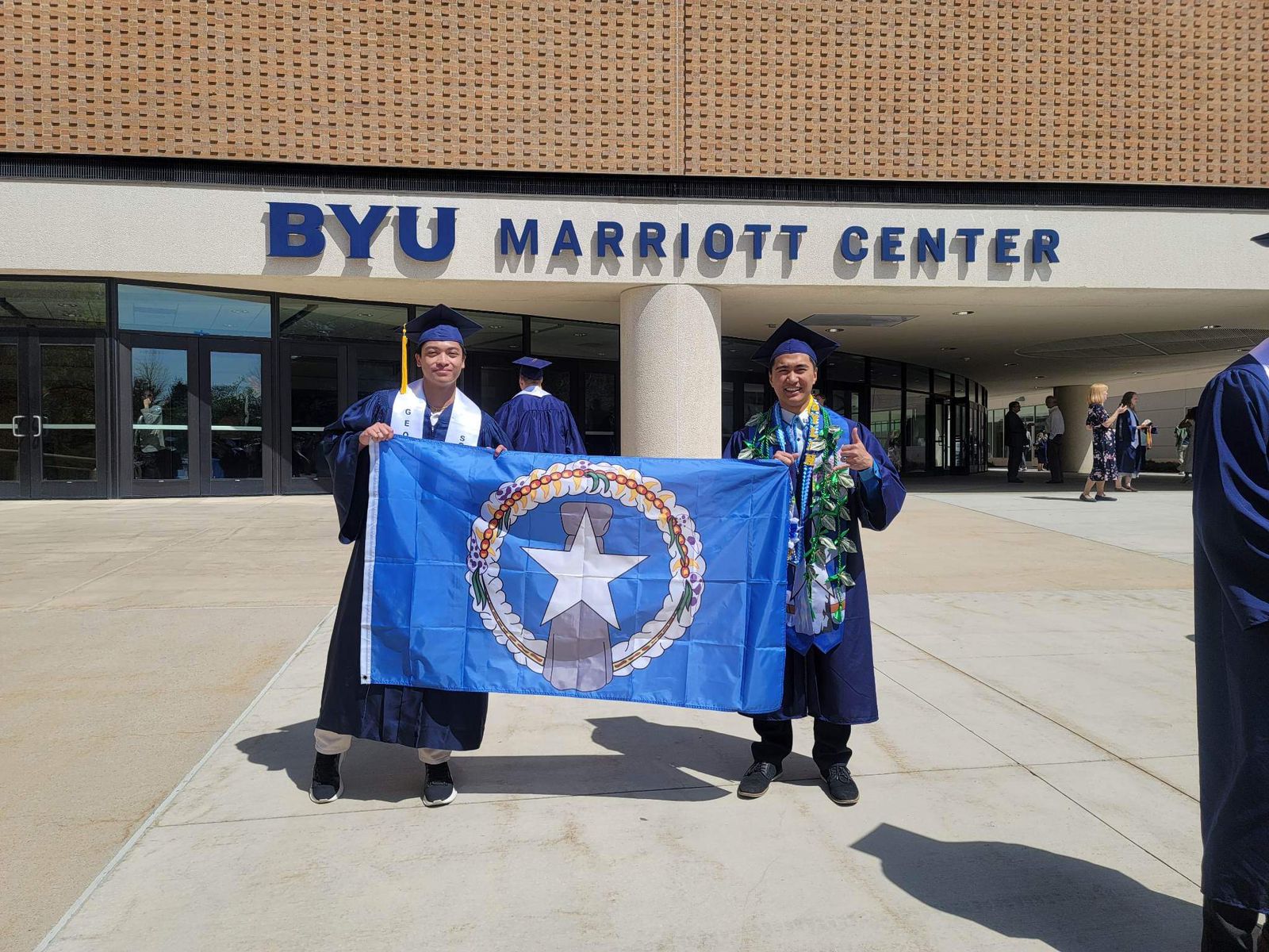 Carl Jericho Lambat, left, and Dylan James Sablan display the CNMI flag after graduating from Brigham Young University in Provo, Utah.