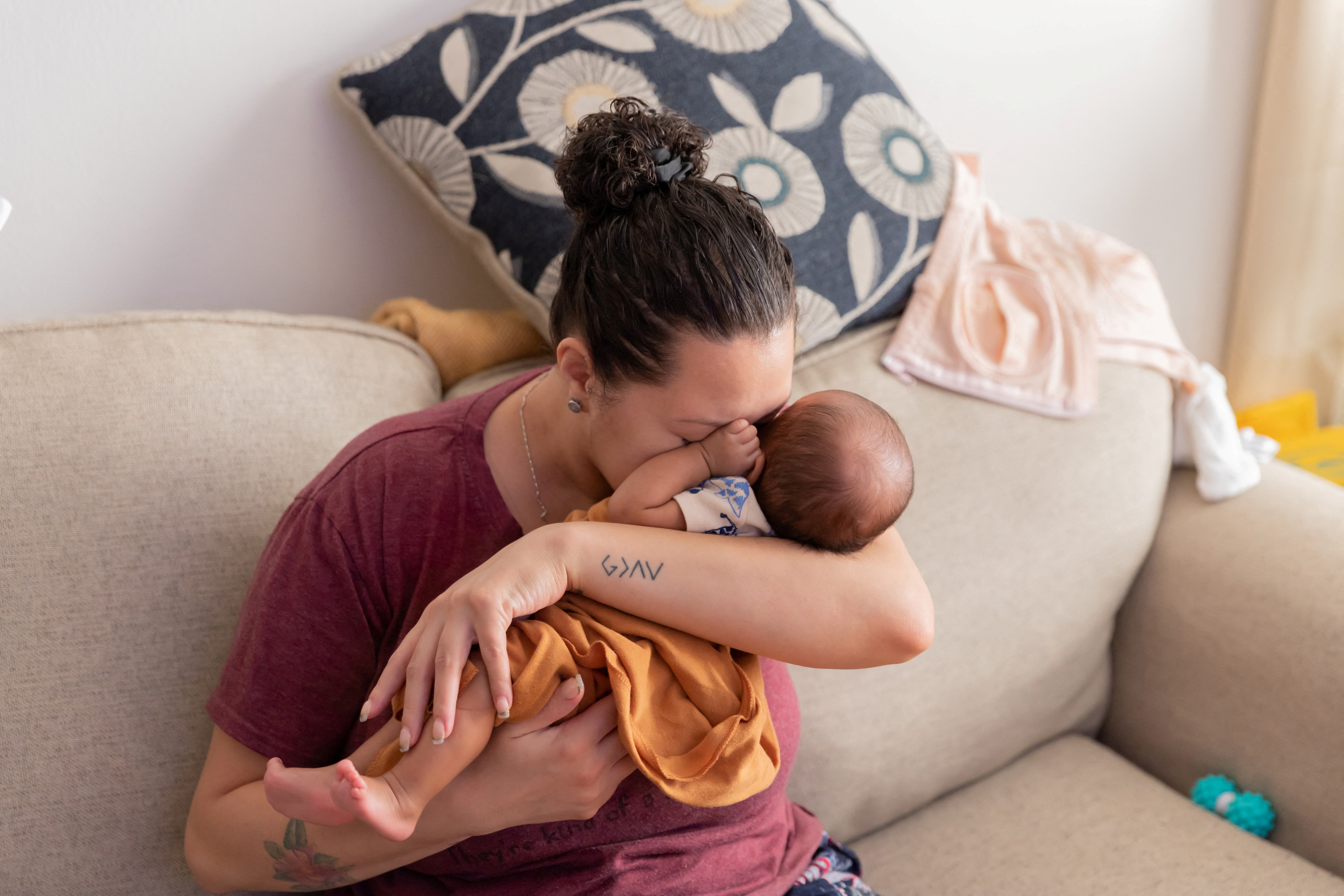 Program manager Shariah Bottex, 30, cuddles her newborn son Kaiel in Flushing, New York, U.S., March 16, 2023. REUTERS/Joy Malone