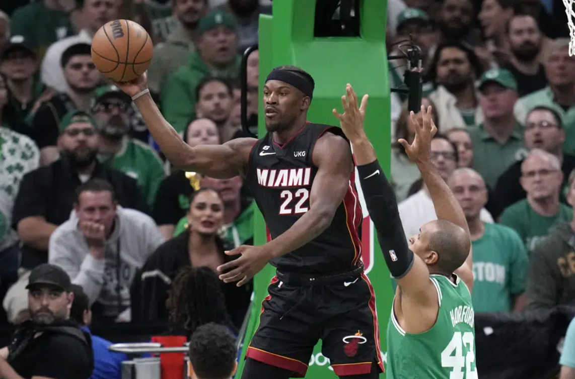 Miami Heat forward Jimmy Butler, left, passes while under pressure from Boston Celtics center Al Horford during the first half in Game 7 of the NBA basketball Eastern Conference finals Monday, May 29, 2023, in Boston.