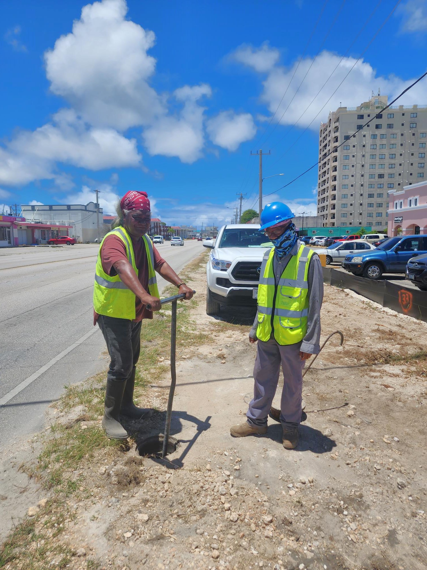 Commonwealth Utilities Corporation Water Division staffer Abraham Igisair, left, locks the valve of the main water line to prevent further water leakage after a back hoe operator hit a water pipe in Chalan Kanoa on Wednesday.