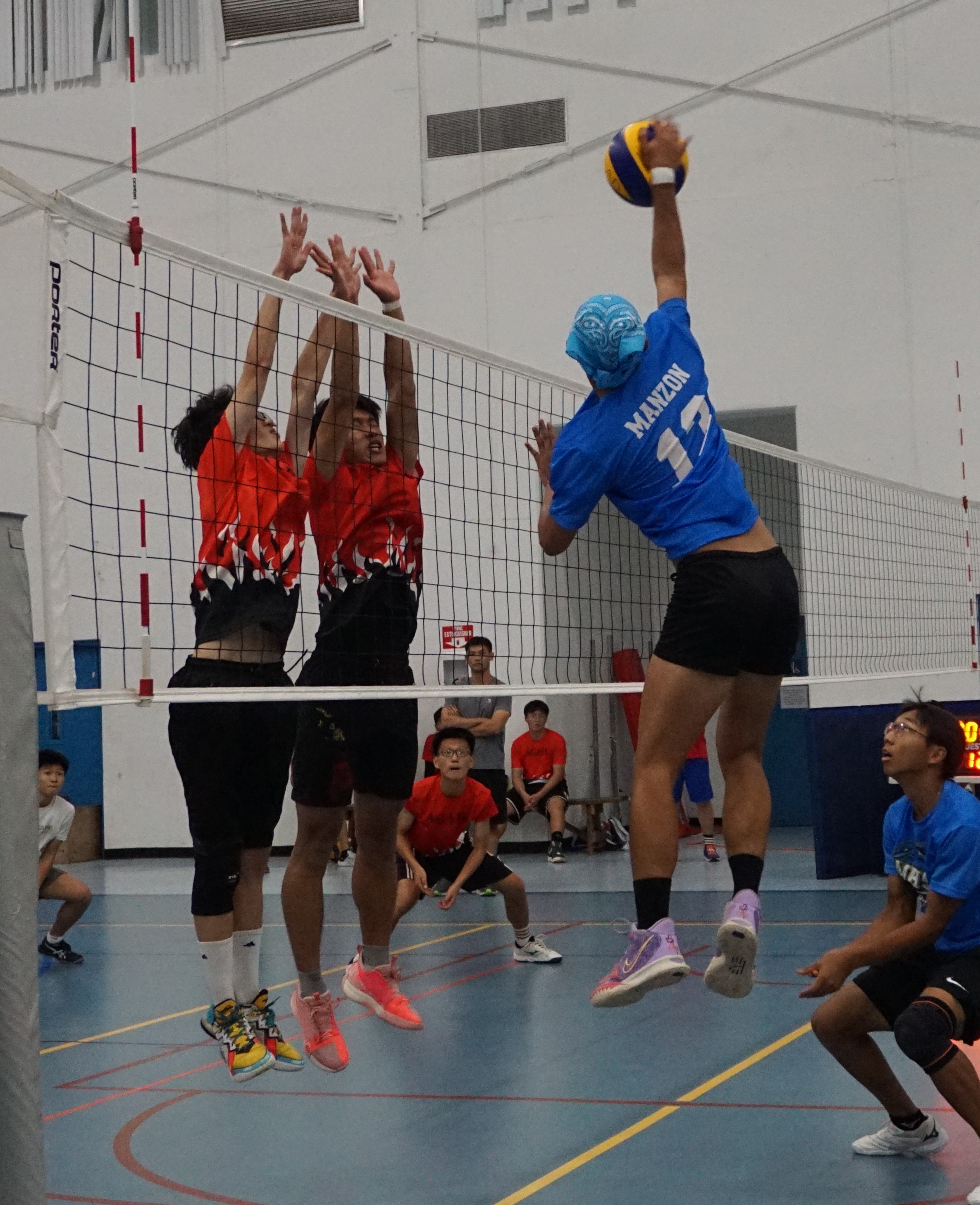 Two Agape Christian School defenders reach out to block a spike unleashed by Marianas High School’s Manzon during the championship match in the boys high school division of the PSS-NMIVA Interscholastic Volleyball League at the MHS gym on Saturday.