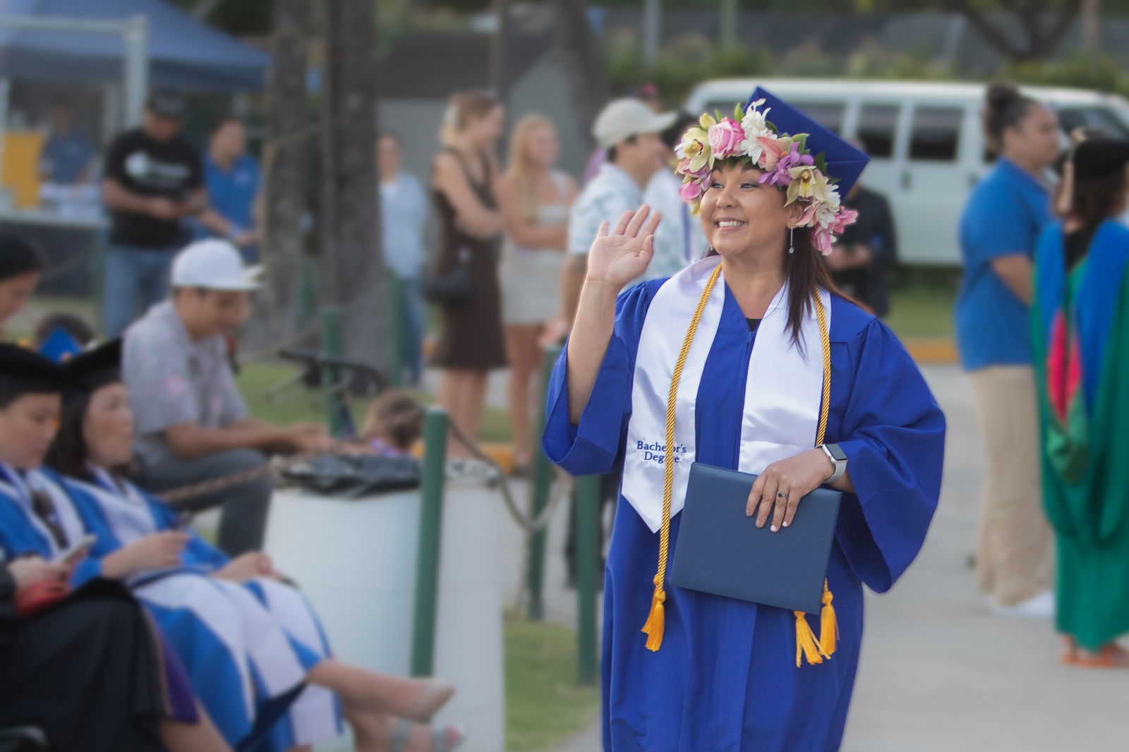 Linda Yoshimoto smiles and waves to family after receiving her diploma.