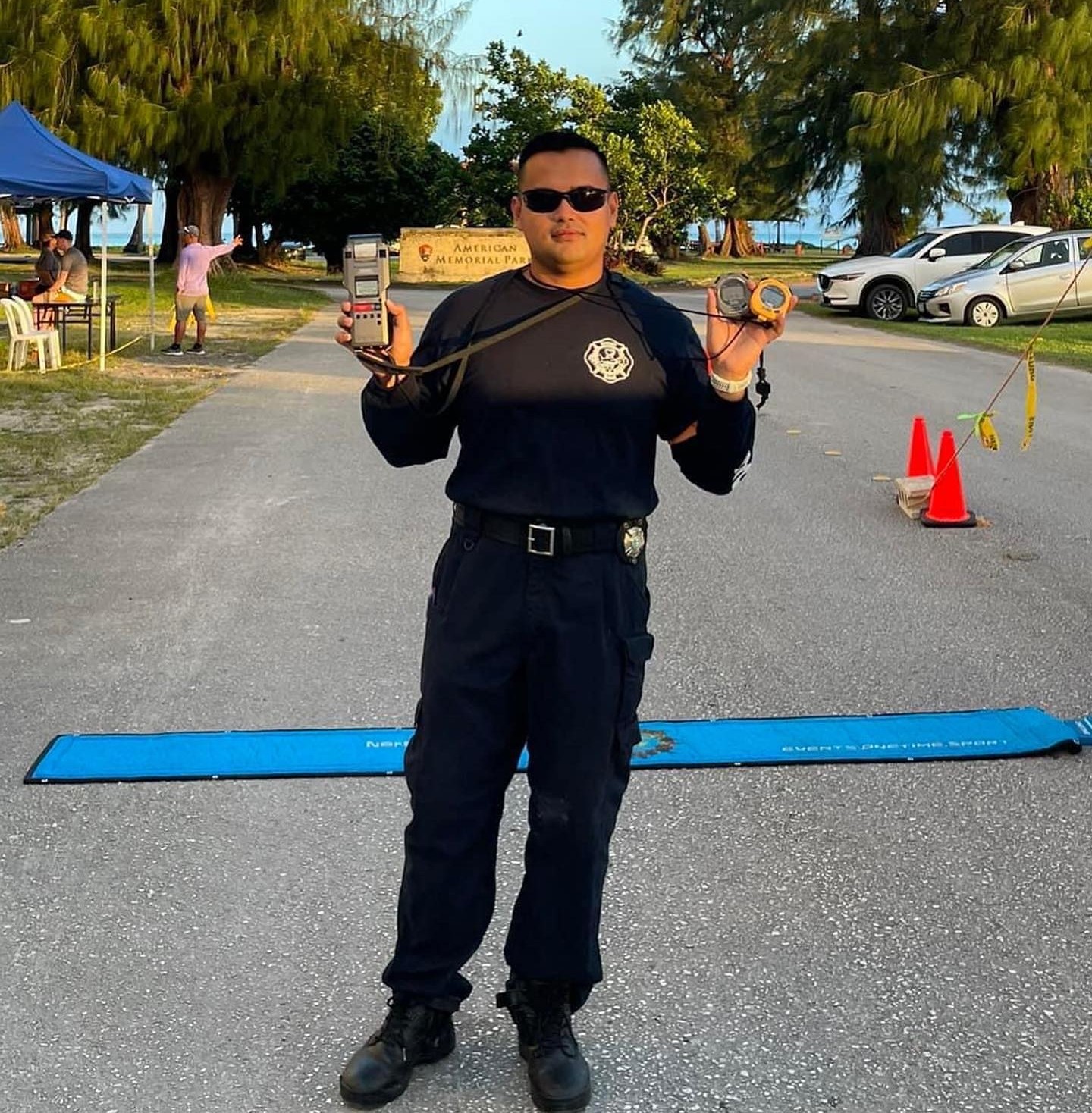 Edward Dela Cruz Jr. holds two timers during a Run Saipan race he single-handedly hosted.