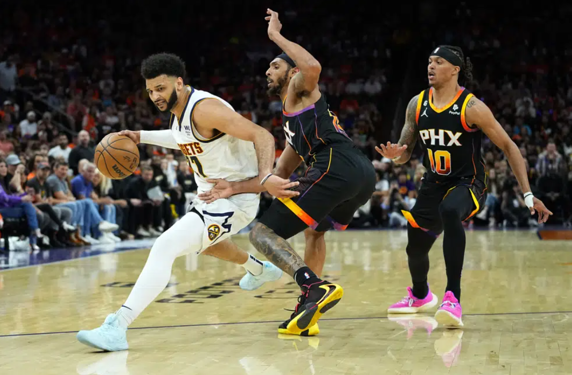 Denver Nuggets guard Jamal Murray (27) drives around Phoenix Suns guard Cameron Payne during the second half of Game 6 of an NBA basketball Western Conference semifinal series, Thursday, May 11, 2023, in Phoenix. The Nuggets eliminated the Sun in their 125-100 win.