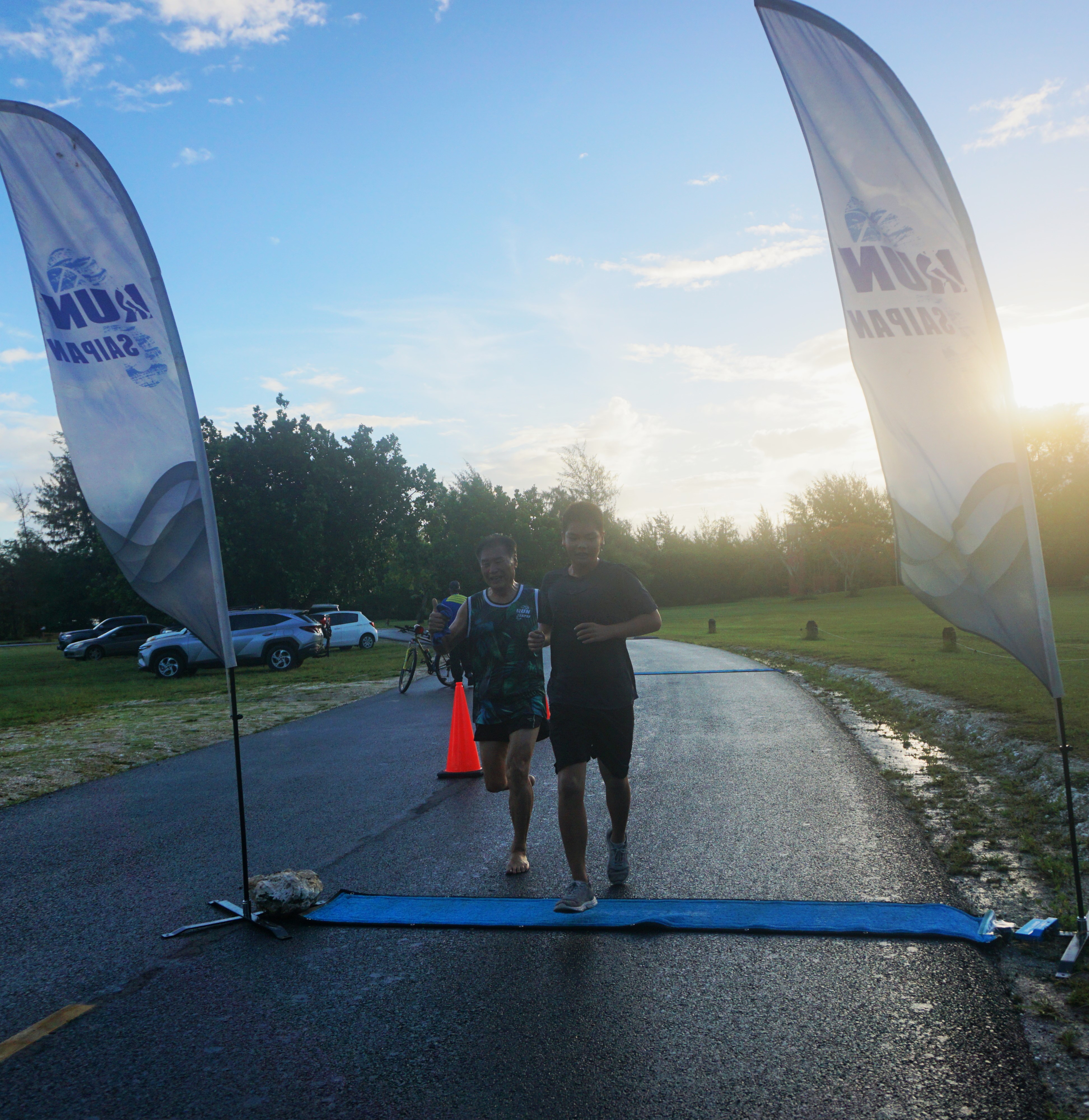 Young Jun Lin, right, passes Chong Nam Lee to finish first in Run Saipan’s Mangrove 5K Run Saturday at American Memorial Park.
