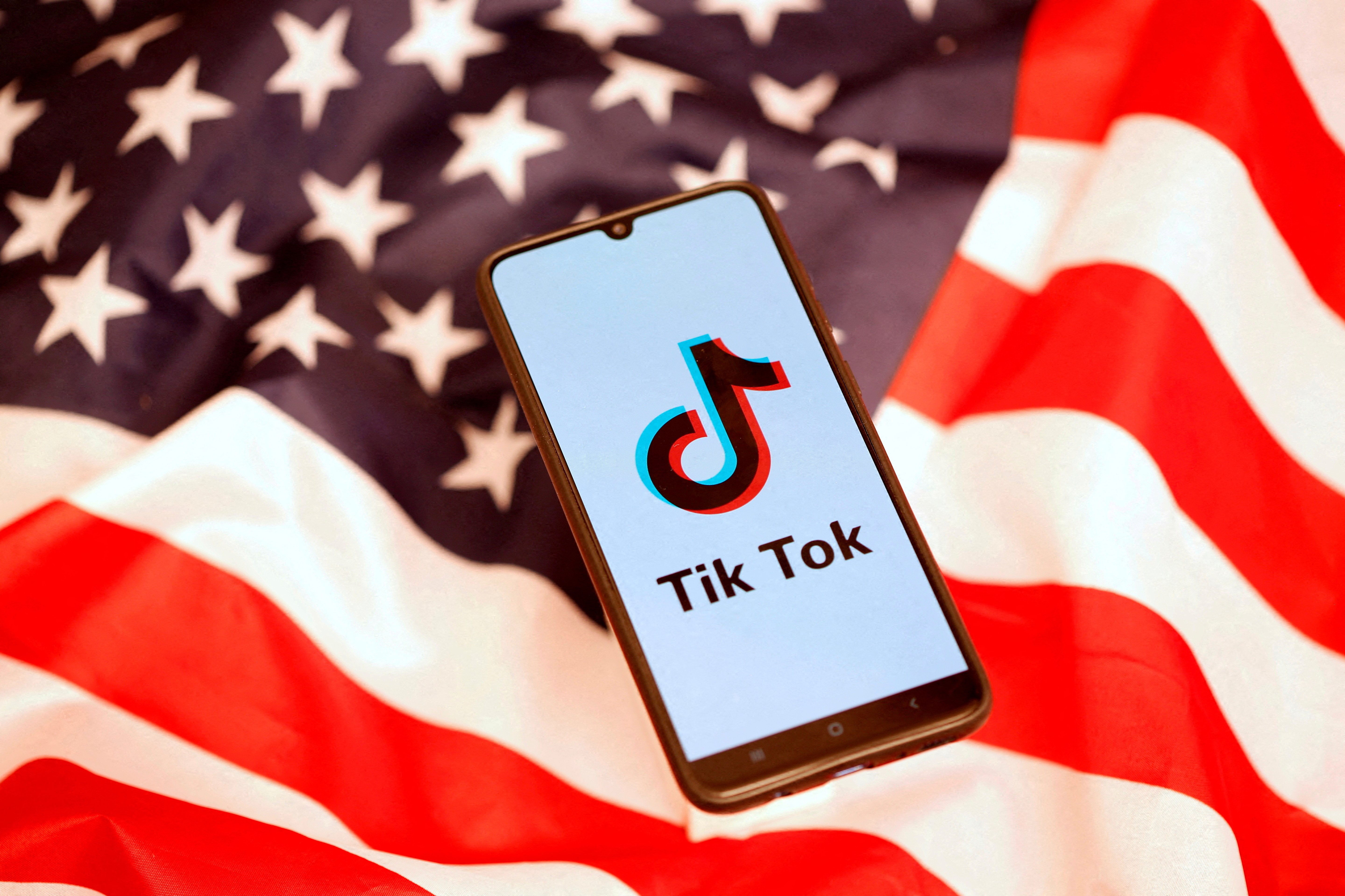 FILE PHOTO: FTikTok logo is displayed on the smartphone while standing on the U.S. flag in this illustration picture taken, November 8, 2019. REUTERS/Dado Ruvic/File Photo