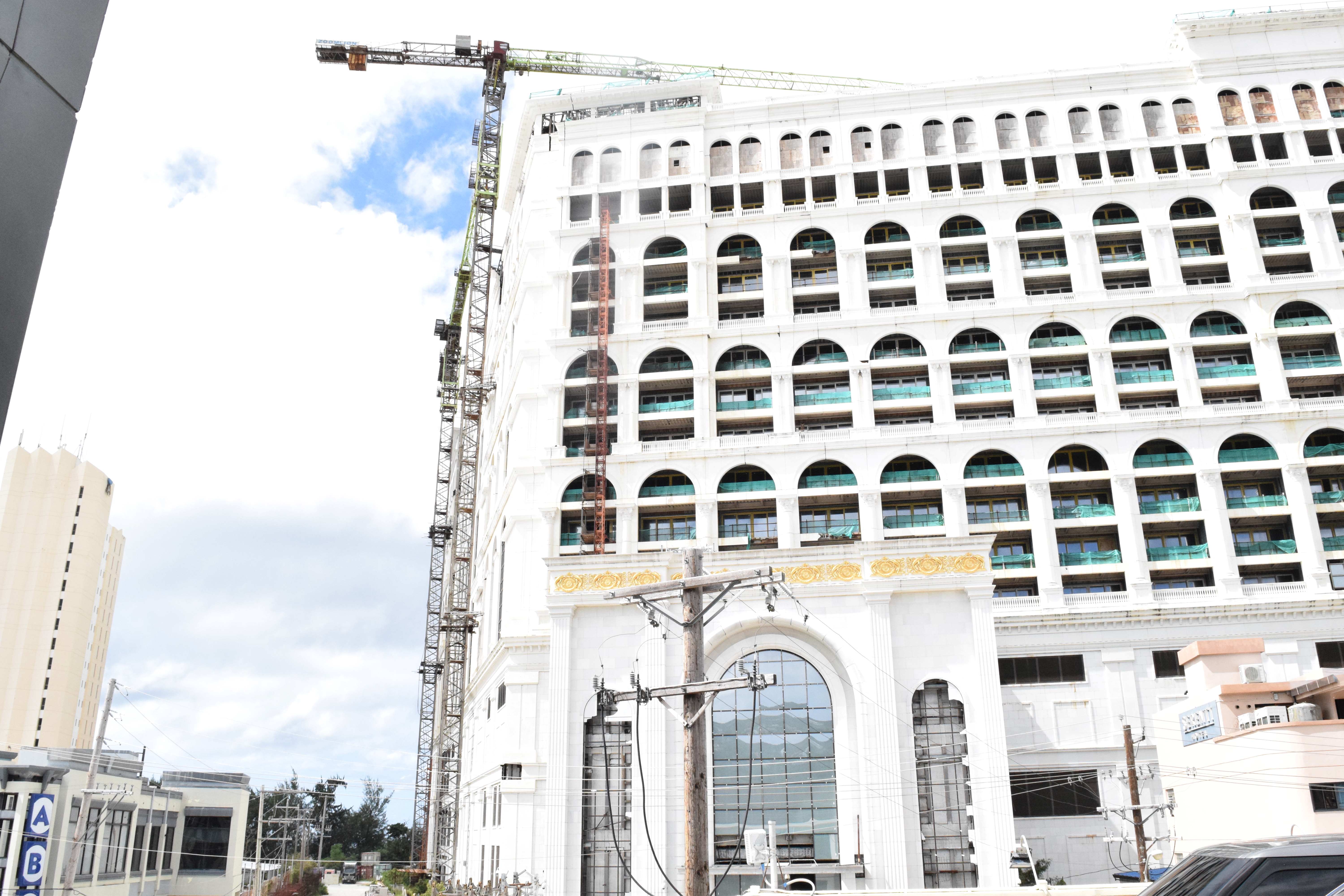 Tower crane No. 5 at the unfinished Imperial Pacific International casino-hotel is seen on Hibiscus Lane, across from a commercial complex in Garapan.