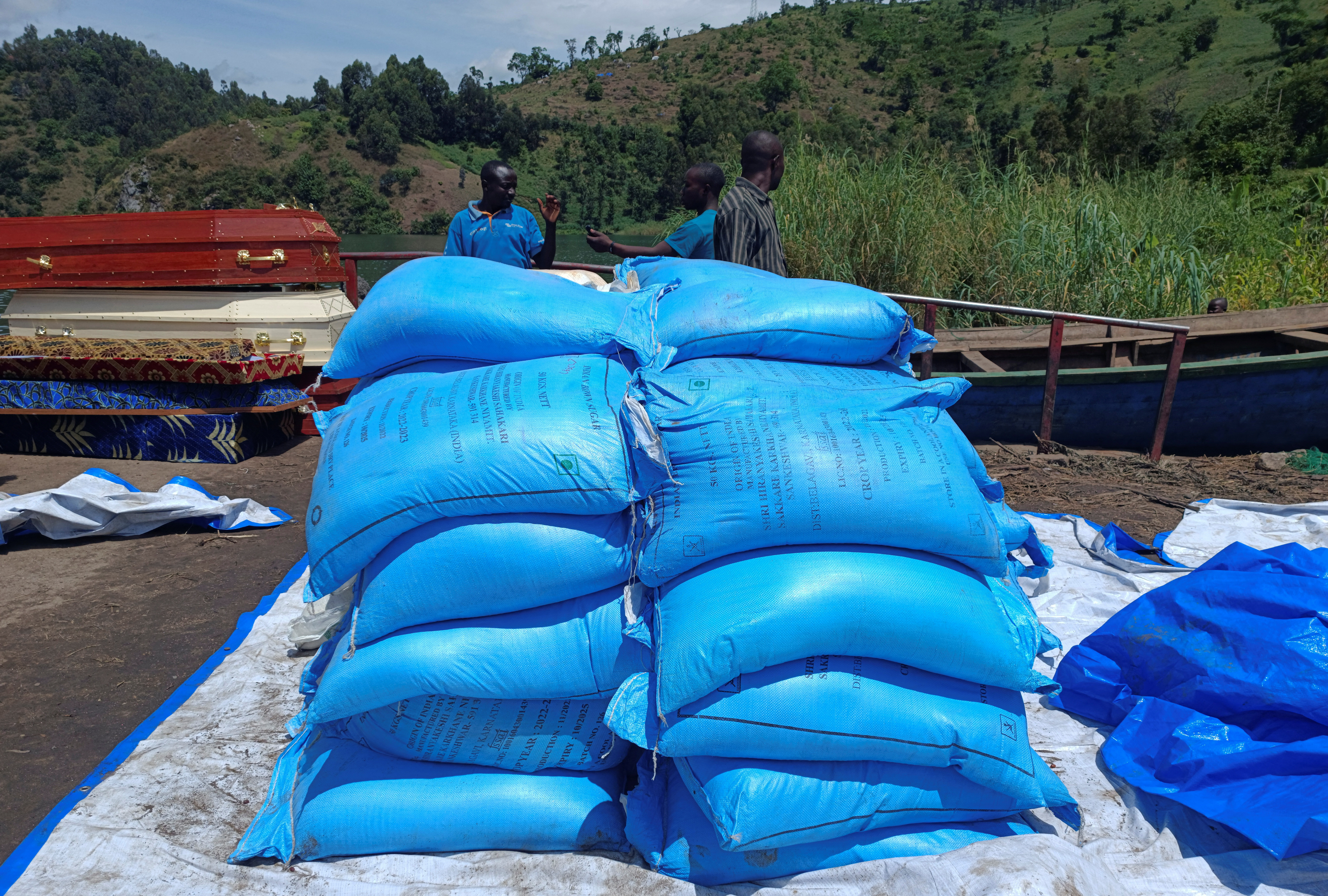 Workers arrange humanitarian relief and coffins for the Congolese civilians killed following rains that destroyed the remote, mountainous area and ripped through the riverside villages of Nyamukubi, Kalehe territory in South Kivu province of the Democratic Republic of Congo May 9, 2023. REUTERS/Djaffar Sabiti