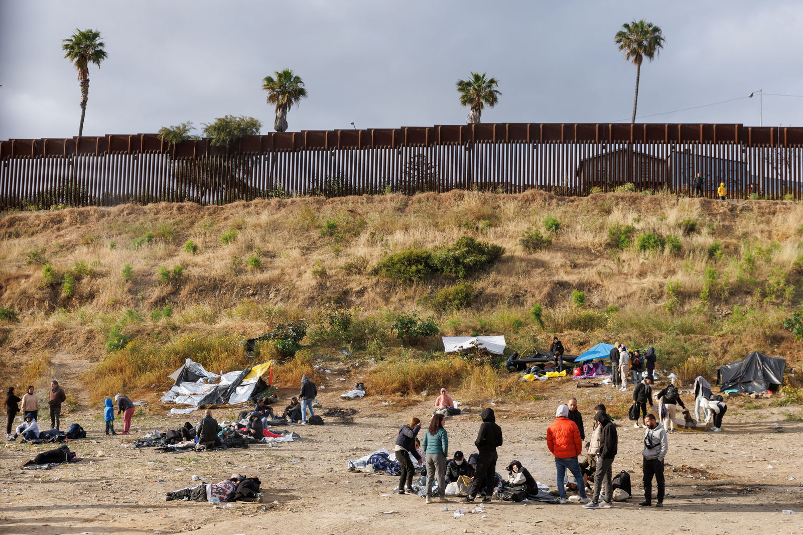 Migrants gather between primary and secondary border fences as the United States prepares to lift COVID-19 era Title 42 restrictions that have blocked migrants at the U.S.-Mexico border from seeking asylum since 2020 near San Diego, California, U.S., May 9, 2023. REUTERS/Mike Blake