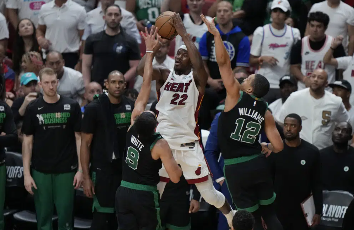 Boston Celtics guard Derrick White (9) and forward Grant Williams (12) defend Miami Heat forward Jimmy Butler (22) during the first half of Game 3 of the NBA basketball playoffs Eastern Conference finals, Sunday, May 21, 2023, in Miami.