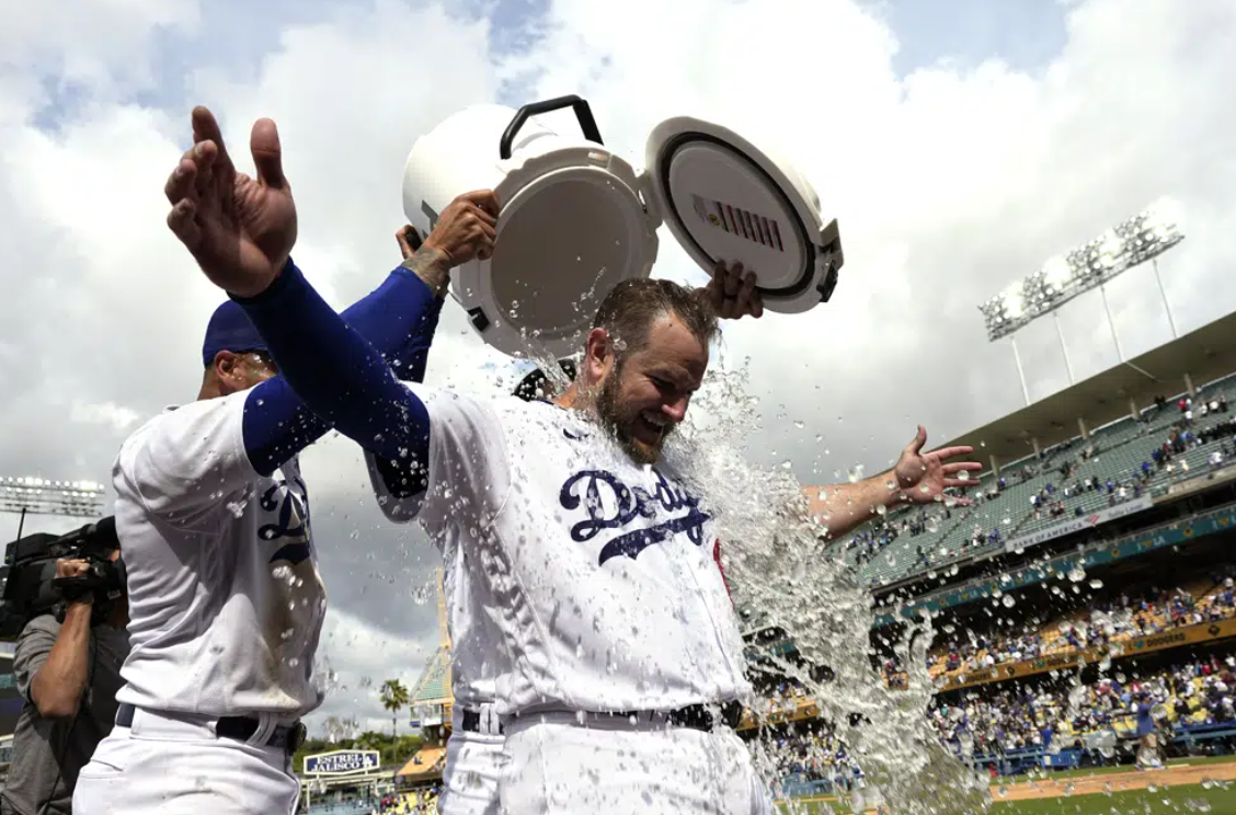 Los Angeles Dodgers' Max Muncy, right, has water dumped on him by David Peralta, left, and James Outman after hitting a walk-off grand slam during the ninth inning of a baseball game against the Philadelphia Phillies Wednesday, May 3, 2023, in Los Angeles. The Dodgers won 10-6.
