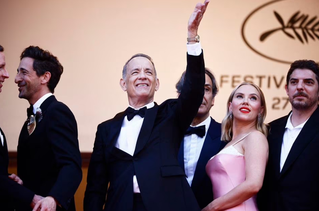 "Asteroid City" cast member Tom Hanks gestures next to Scarlett Johansson and Adrien Brody during the red carpet arrivals at the 76th Cannes Film Festival in Cannes, France, May 23, 2023.
