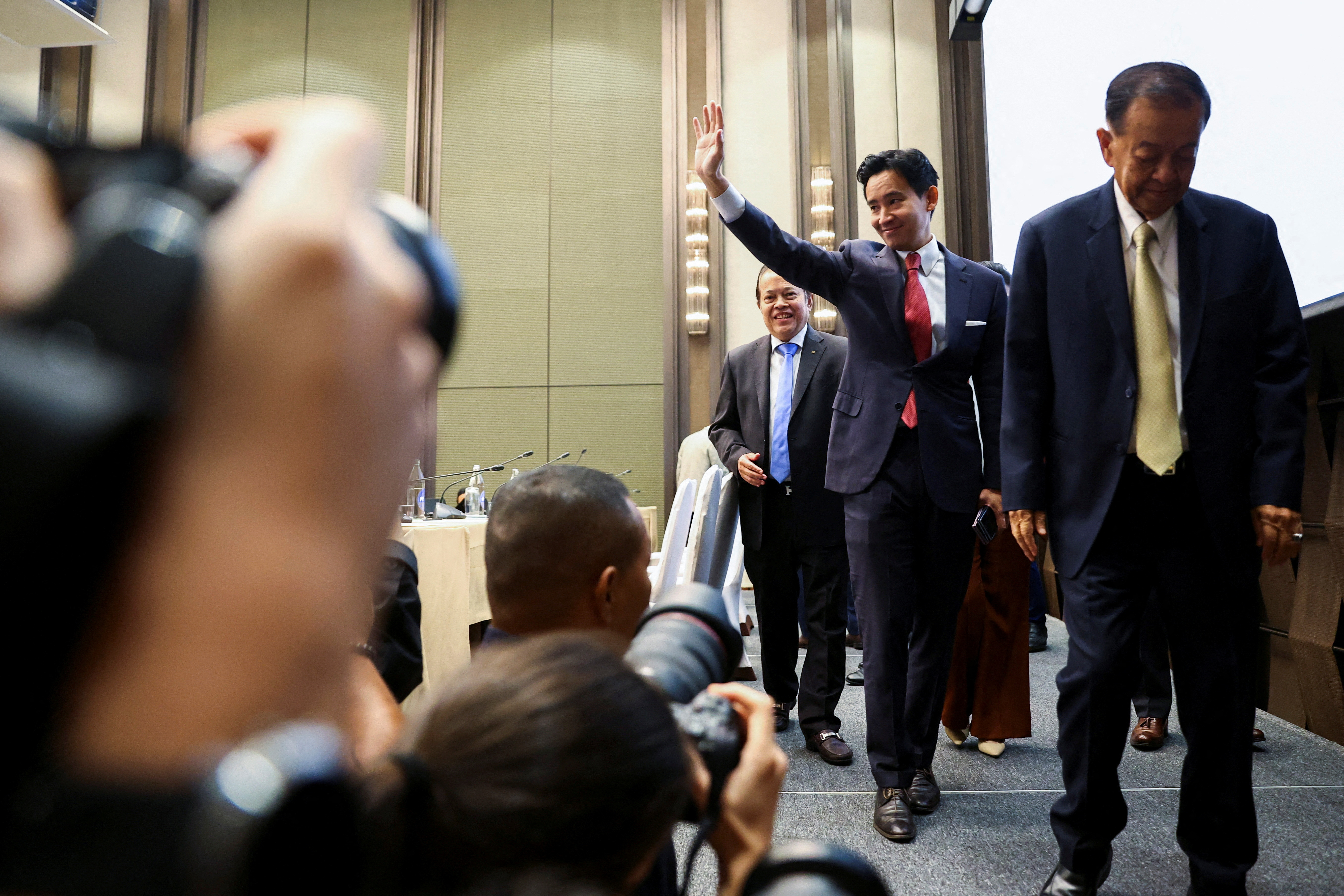Move Forward Party leader Pita Limjaroenrat waves as he walks following a meeting with coalition partners in Bangkok, Thailand, May 18, 2023. REUTERS/Athit Perawongmetha REFILE - QUALITY REPEAT