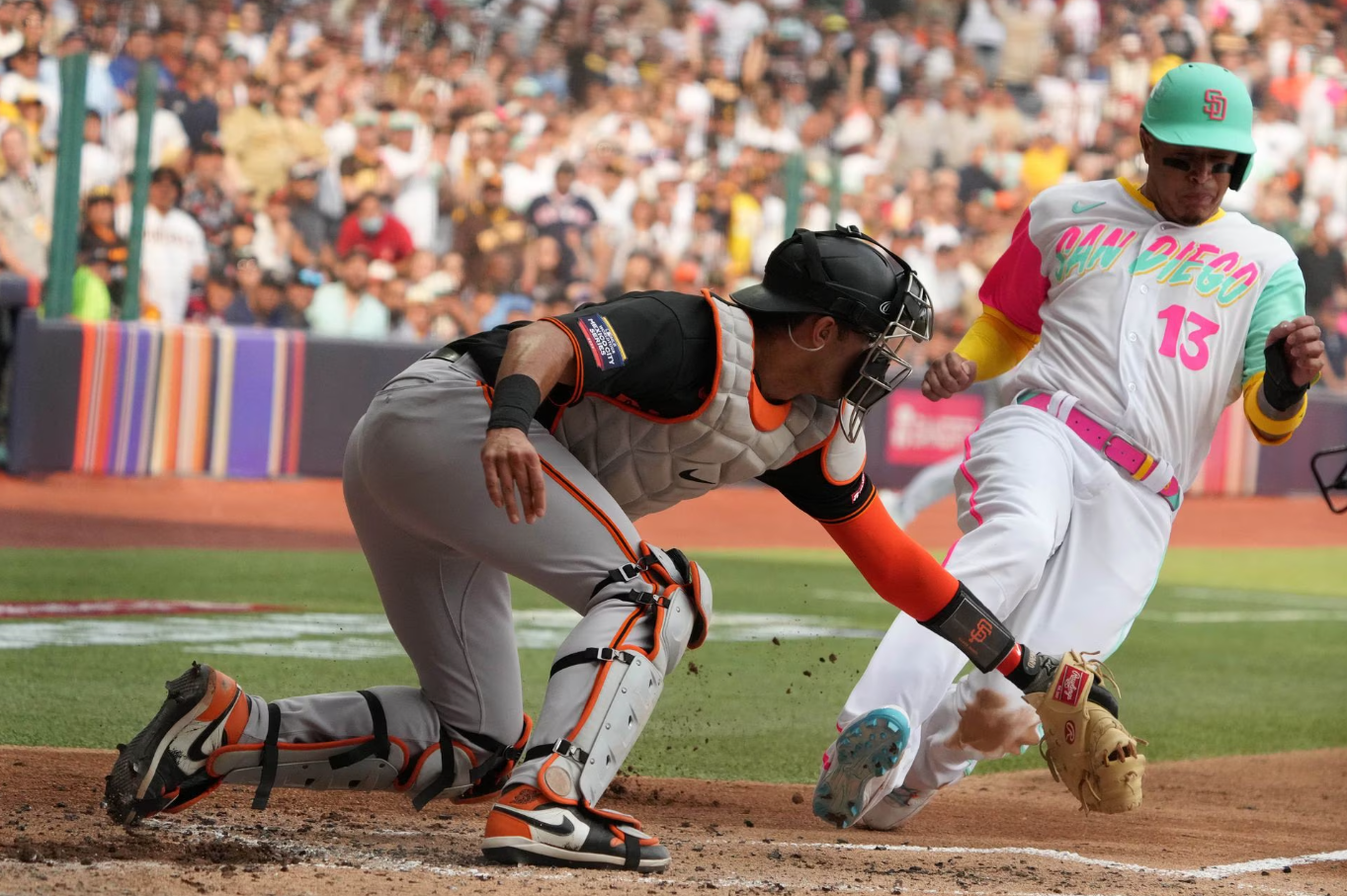 San Diego Padres third baseman Manny Machado (13) slides into home plate to score against San Francisco Giants catcher Blake Sabol (2) in the first inning during a MLB World Tour game at Estadio Alfredo Harp Helu in Mexico City, Mexico, April 29, 2023.