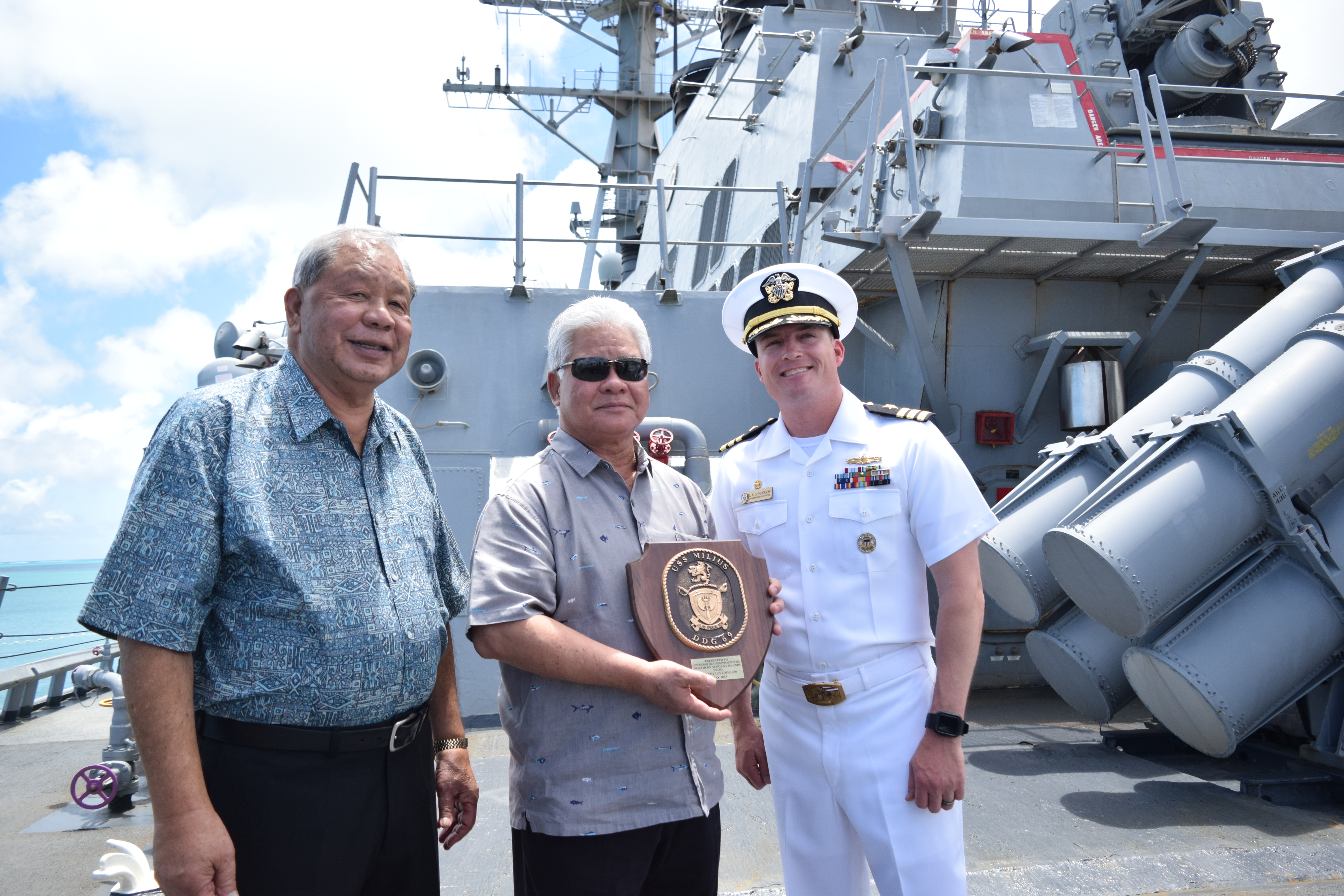 Gov. Arnold I. Palacios, center, holds a USS Milius plaque while he and Lt. Gov. David M. Apatang, left, pose for a photo with the destroyer's commanding officer, CDR Leif Gunderson, at the Port of Saipan on Thursday.