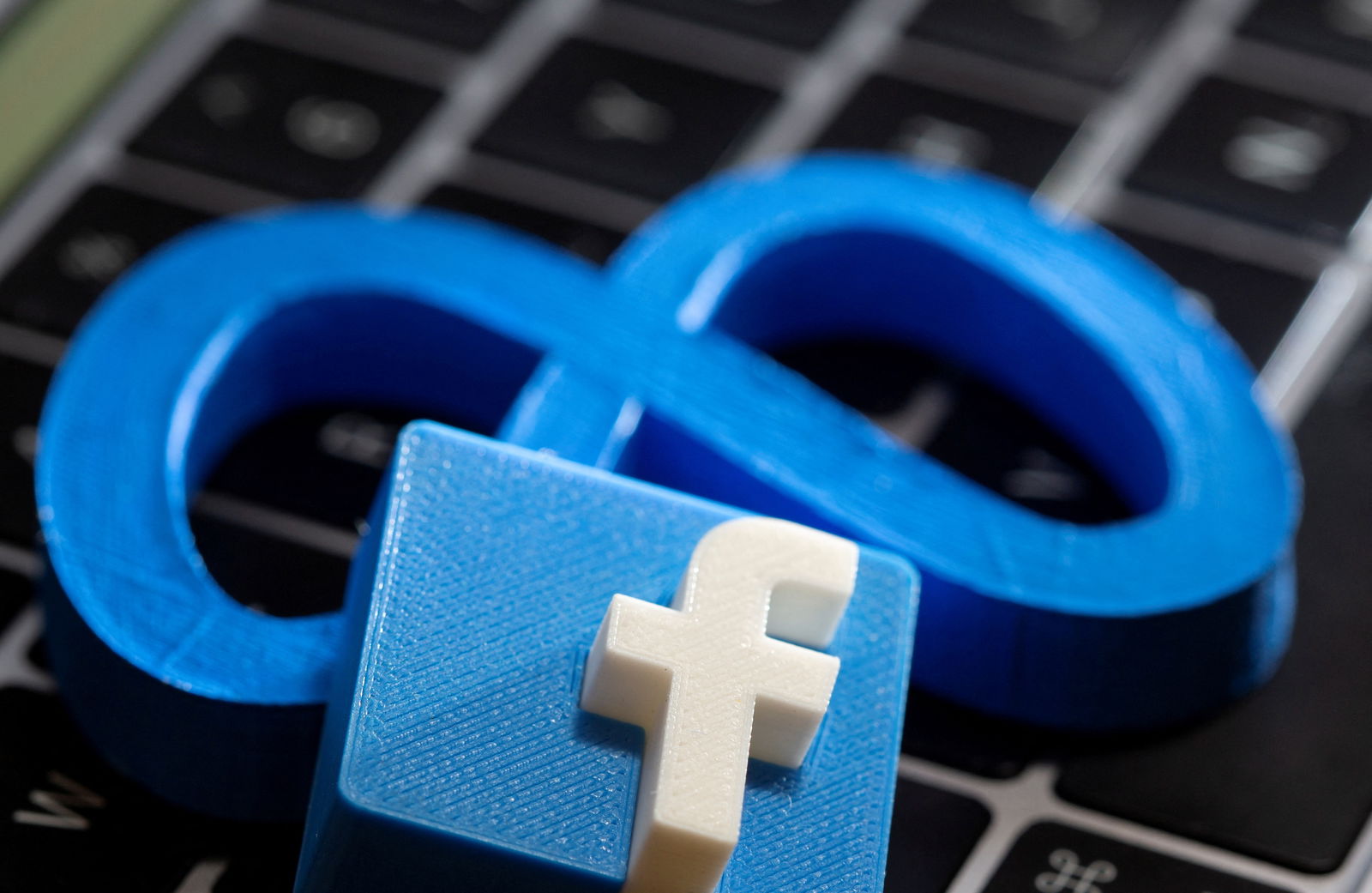 FILE PHOTO: A 3D printed Facebook's new rebrand logo Meta and Facebook logo are placed on laptop keyboard in this illustration taken on November 2, 2021. REUTERS/Dado Ruvic