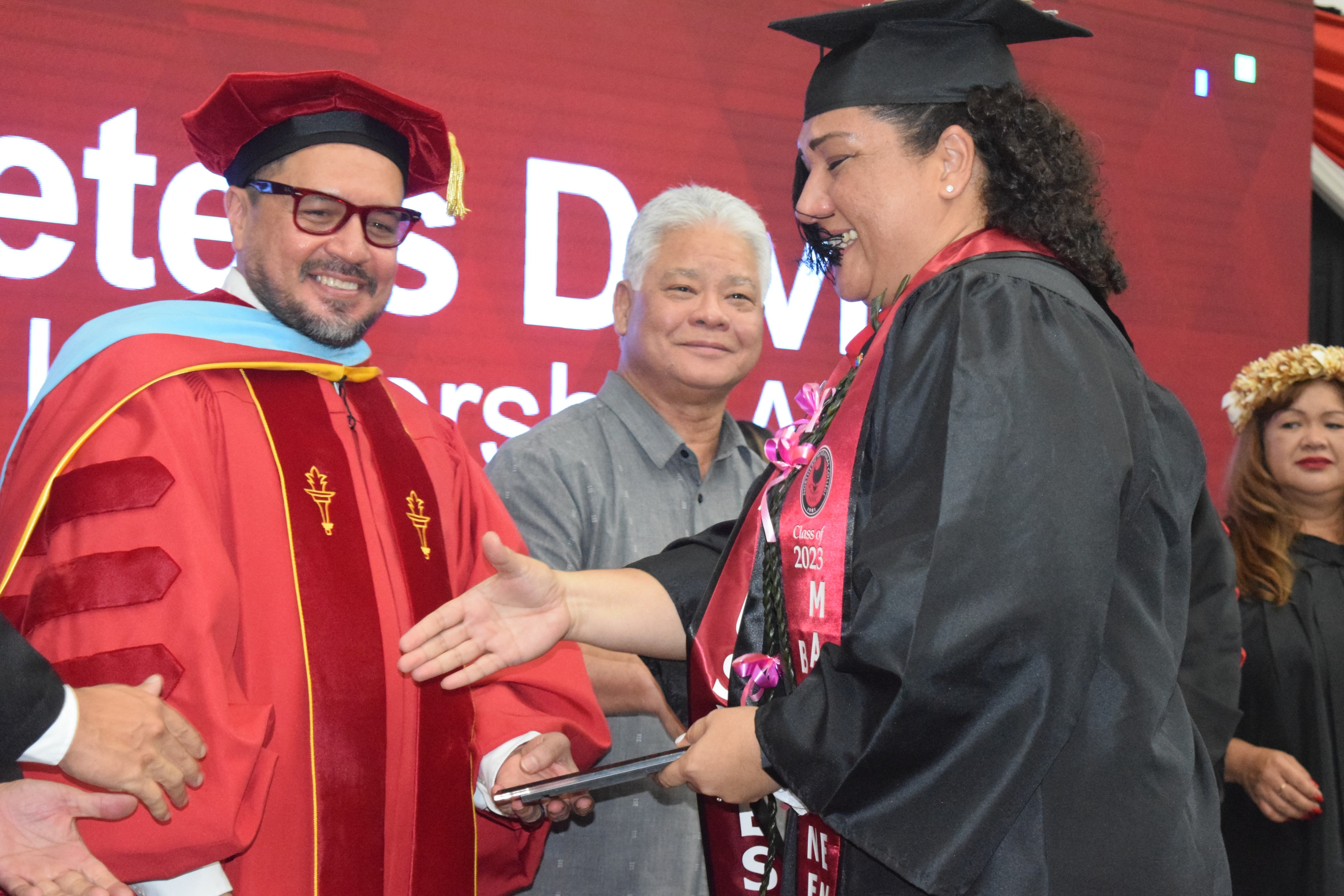 Gov. Arnold I. Palacios, center, smiles as Tania David receives the Excellence in Leadership Award from NMC President Dr. Galvin Deleon Guerrero.