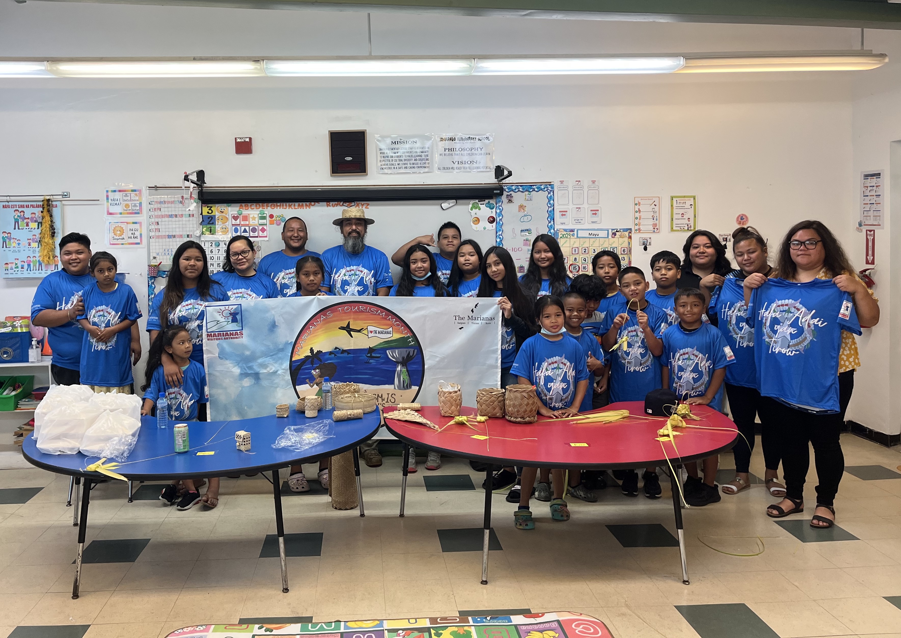 Instructor James Bamba, in hat, conducts a coconut frond weaving class with students of Sinapalo Elementary Chamorro class on May 15, 2023, in Rota. The class was organized by the Marianas Visitors Authority in celebration of Marianas Tourism Month and included teaching on the significance of heritage tourism.