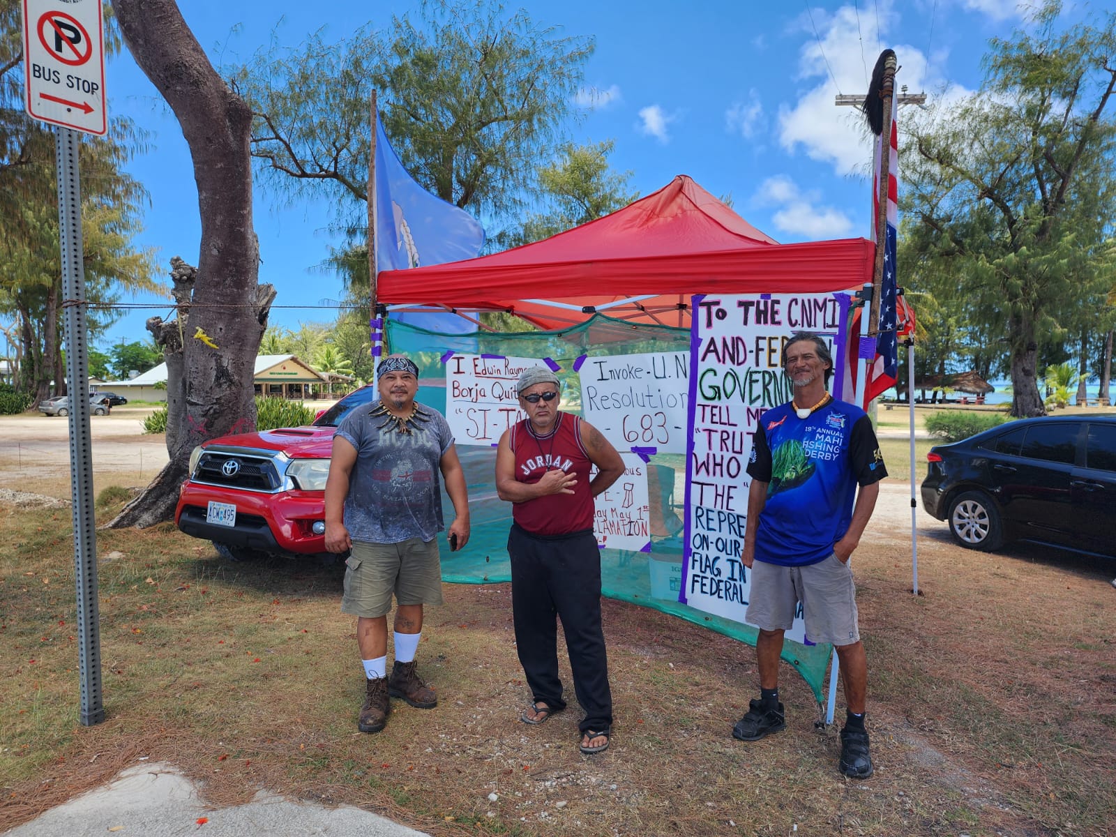 Indigenous rights advocates Raymond Quitugua, Herman Tudela and Godfrey Mendiola hold a peaceful protest in Susupe across from the Guma Hustisia on Tuesday.
