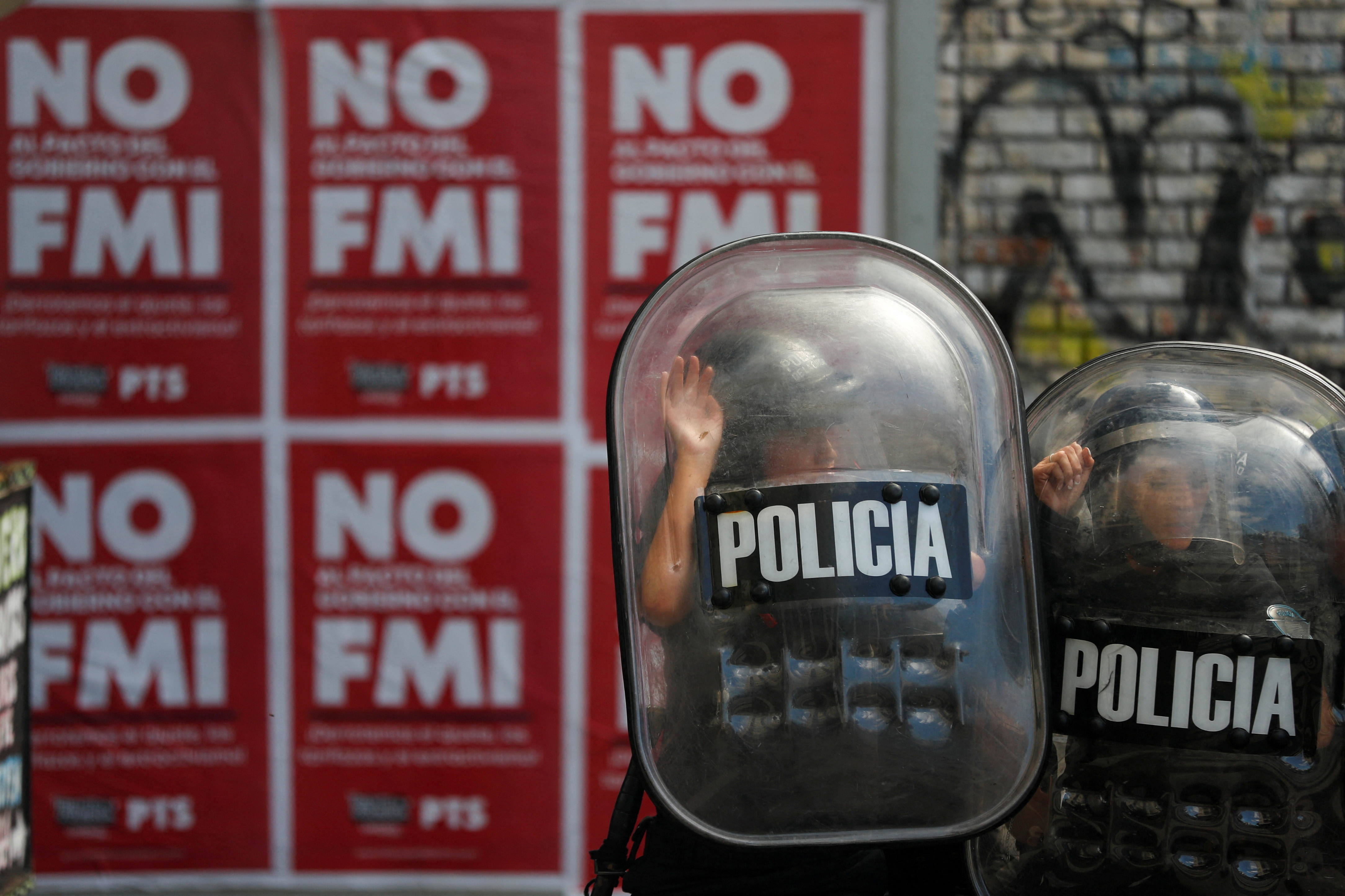 FILE PHOTO: Police officers hide behind shields during a protest outside the National Congress, as members of the parliament debate the government's agreement with the International Monetary Fund (IMF), in Buenos Aires, Argentina March 10, 2022. REUTERS/Agustin Marcarian/File Photo