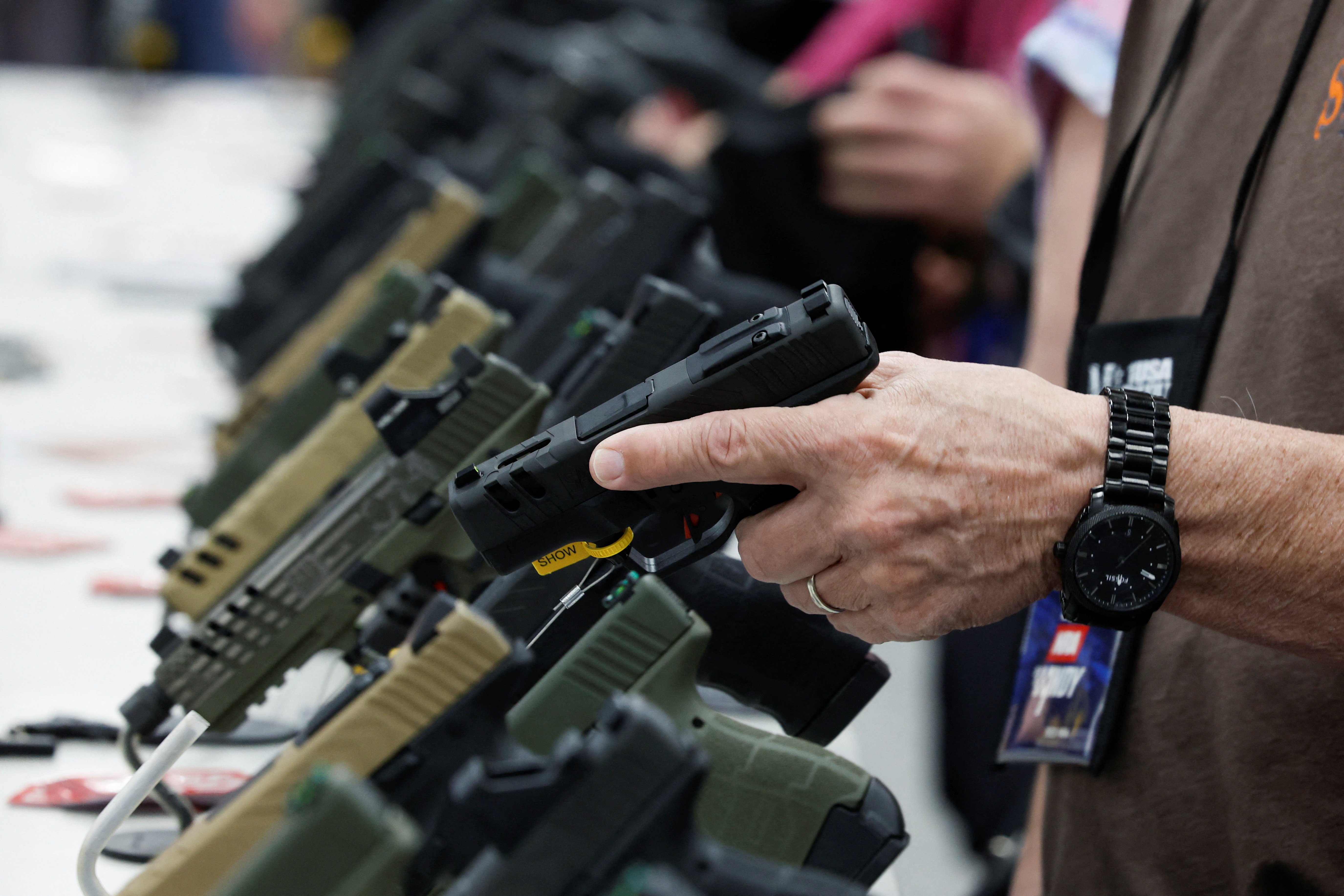 FILE PHOTO: A person tries out a handgun during the National Rifle Association (NRA) annual convention in Indianapolis, Indiana, U.S., April 15, 2023. REUTERS/Evelyn Hockstein