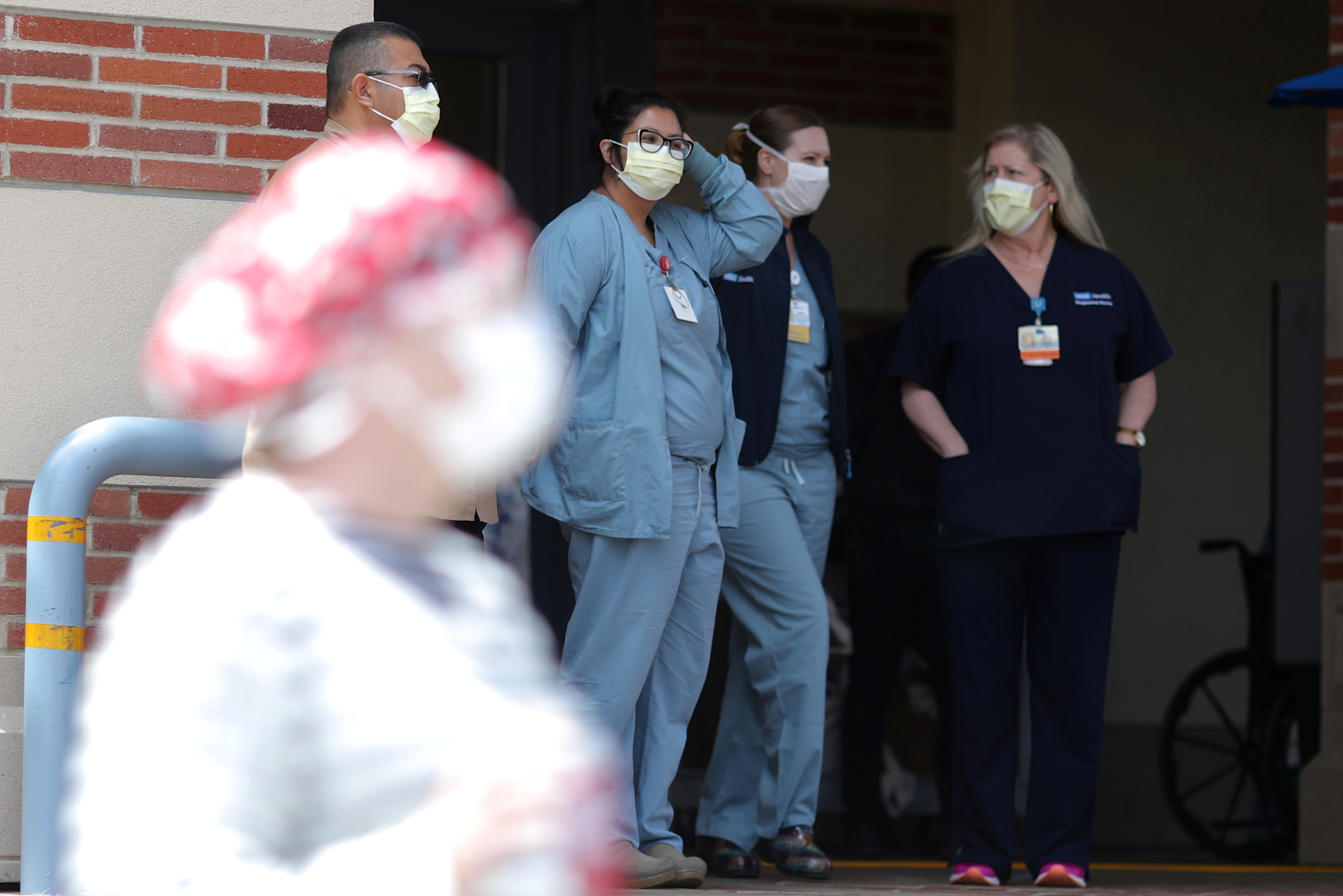 FILE PHOTO: Nurses stand in a hospital doorway watching a nurses’ protest for personal protective equipment at UCLA Medical Center, as the spread of the coronavirus disease (COVID-19) continues, in Los Angeles, California, U.S., April 13, 2020. REUTERS/Lucy Nicholson