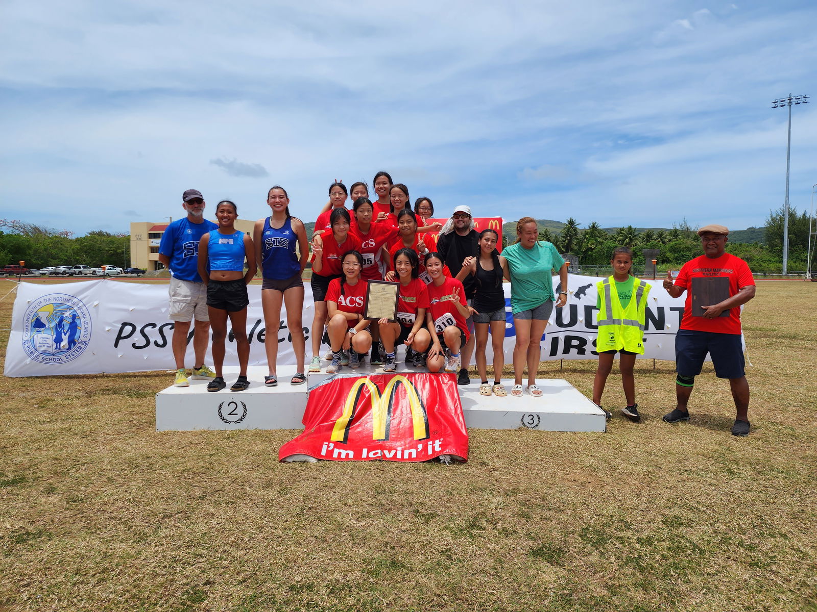 Agape Christian School, Saipan International School, and Saipan Southern High School female athletes pose for a photo with Northern Marianas Athletics President Ray Tebuteb, right, during the awards ceremony for the U18 girls high school division of the PSS-McDonald’s All School Athletics Championships at the Oleai Sports Complex on Saturday.