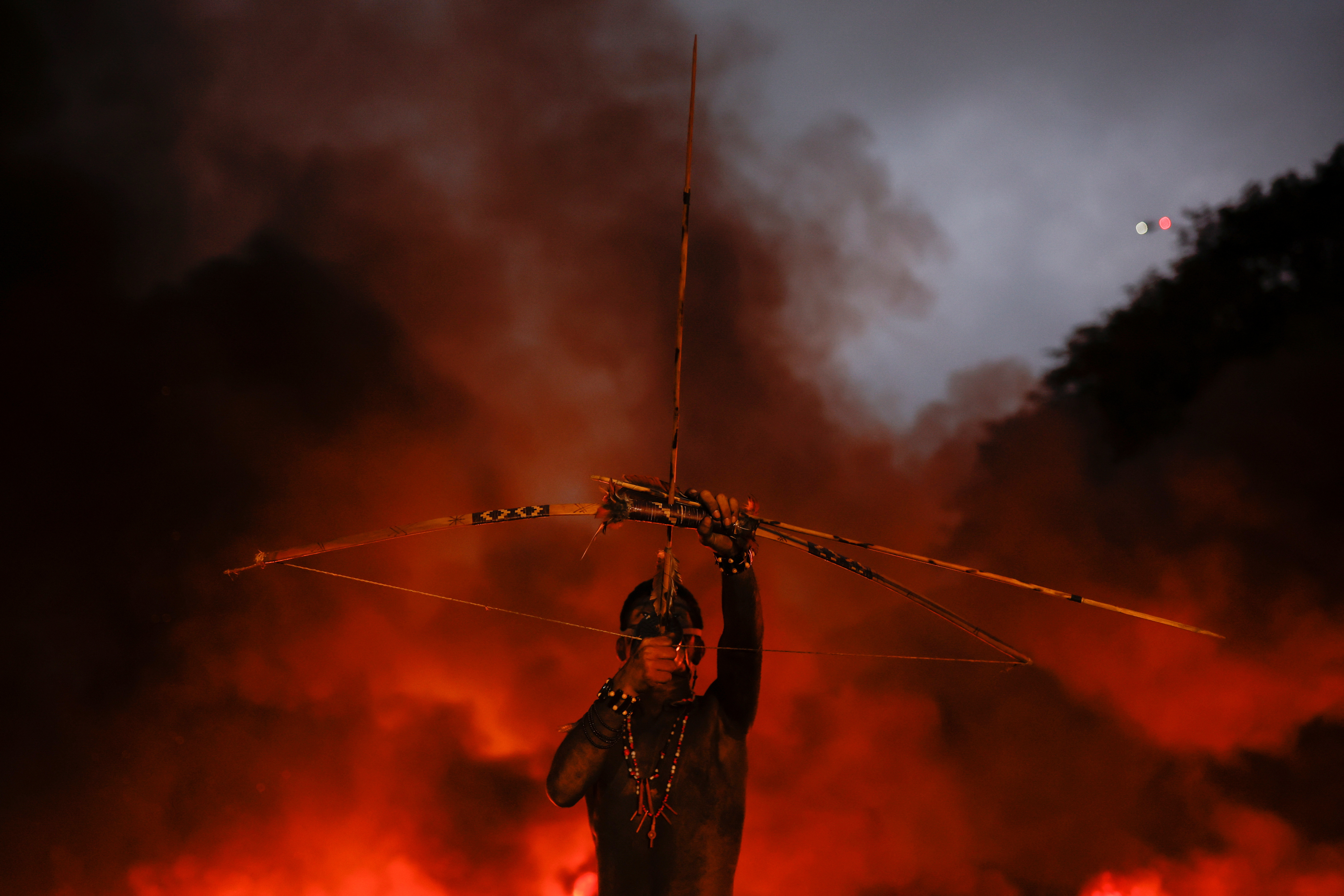 A member of Guarani Mbya Indigenous people uses a bow and arrow during a protest against the so-called legal thesis of "Marco Temporal" (Temporal Milestone) as they close the Bandeirantes highway in Sao Paulo, Brazil May 30, 2023. REUTERS/Amanda Perobelli