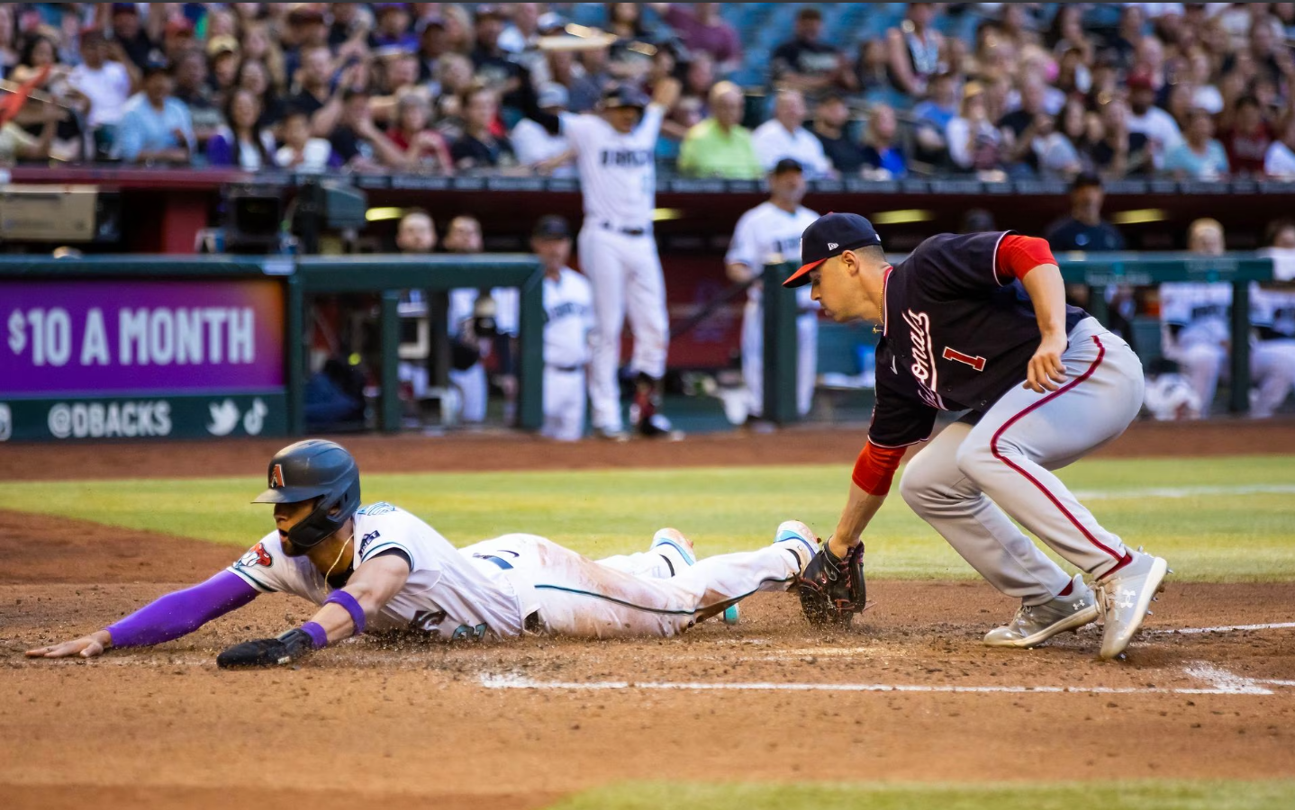 Arizona Diamondbacks base runner Lourdes Gurriel Jr. slides into home to score ahead of the tag from Washington Nationals pitcher MacKenzie Gore after a wild pitch in the sixth inning at Chase Field in Phoenix, Arizona, May 6, 2023.