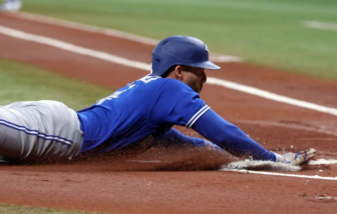 Toronto Blue Jays right fielder George Springer (4) slides home to score a run against the Tampa Bay Rays during the first inning at Tropicana Field in St. Petersburg, Florida,  May 23, 2023.