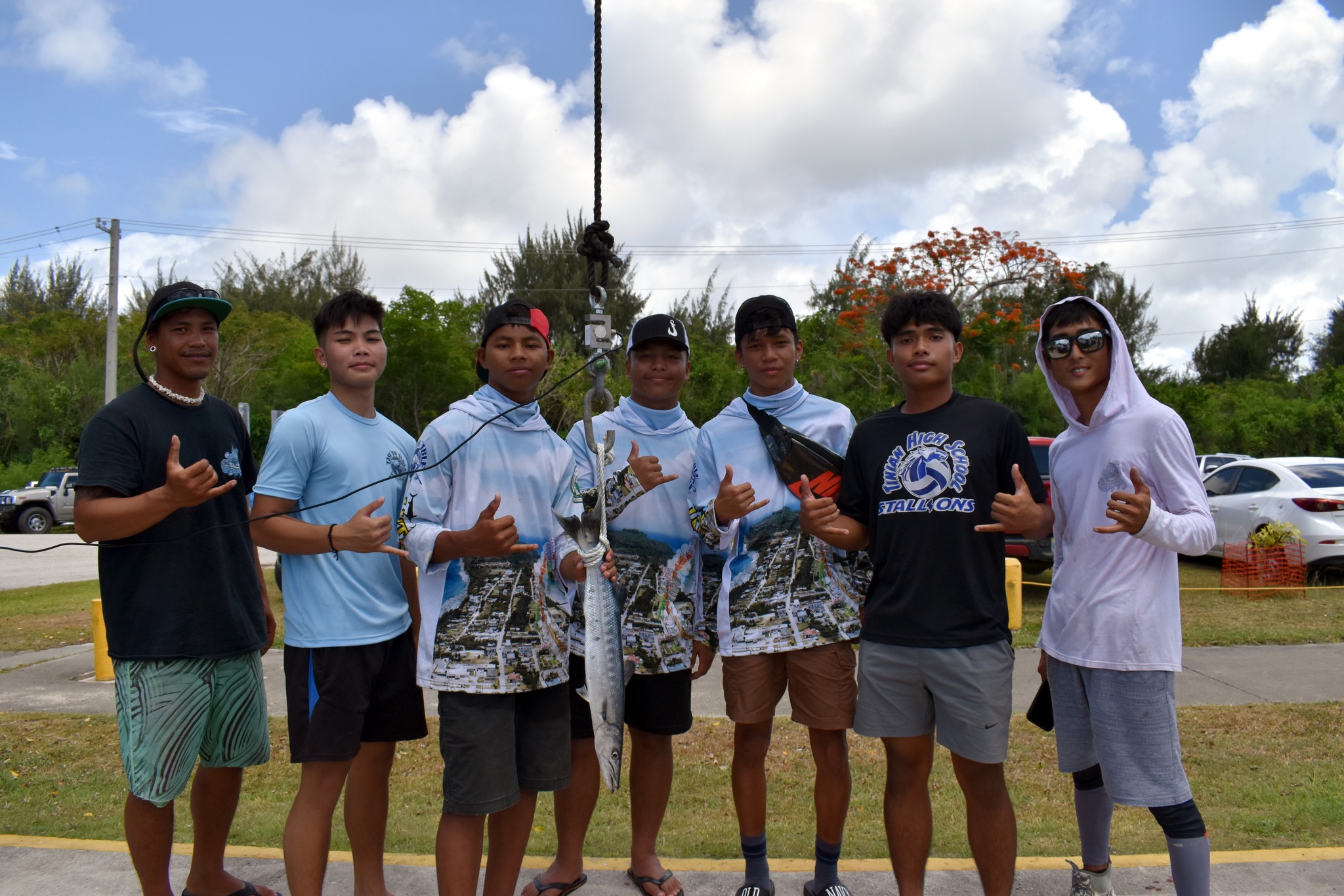 Boat Captain Masaki Kitami, far right, and crew member Kalama Fernandez, far left, take a group photo with TTT students at last year's Mini Derby.