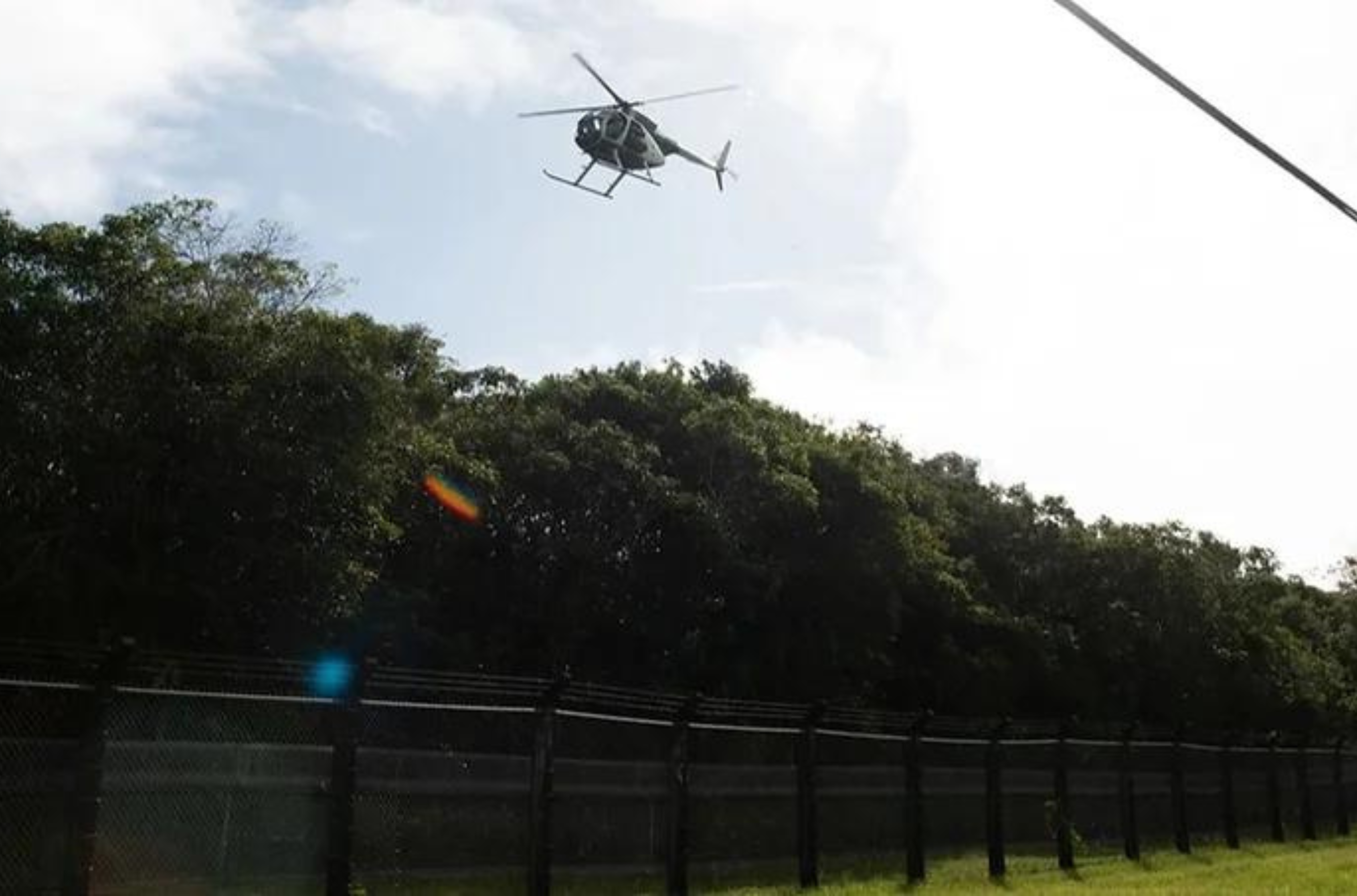 Brown Tree Snake bait is dropped from a USDA UH-6 helicopter as it makes a pass over a fenced habitat management unit on Andersen Air Force Base.