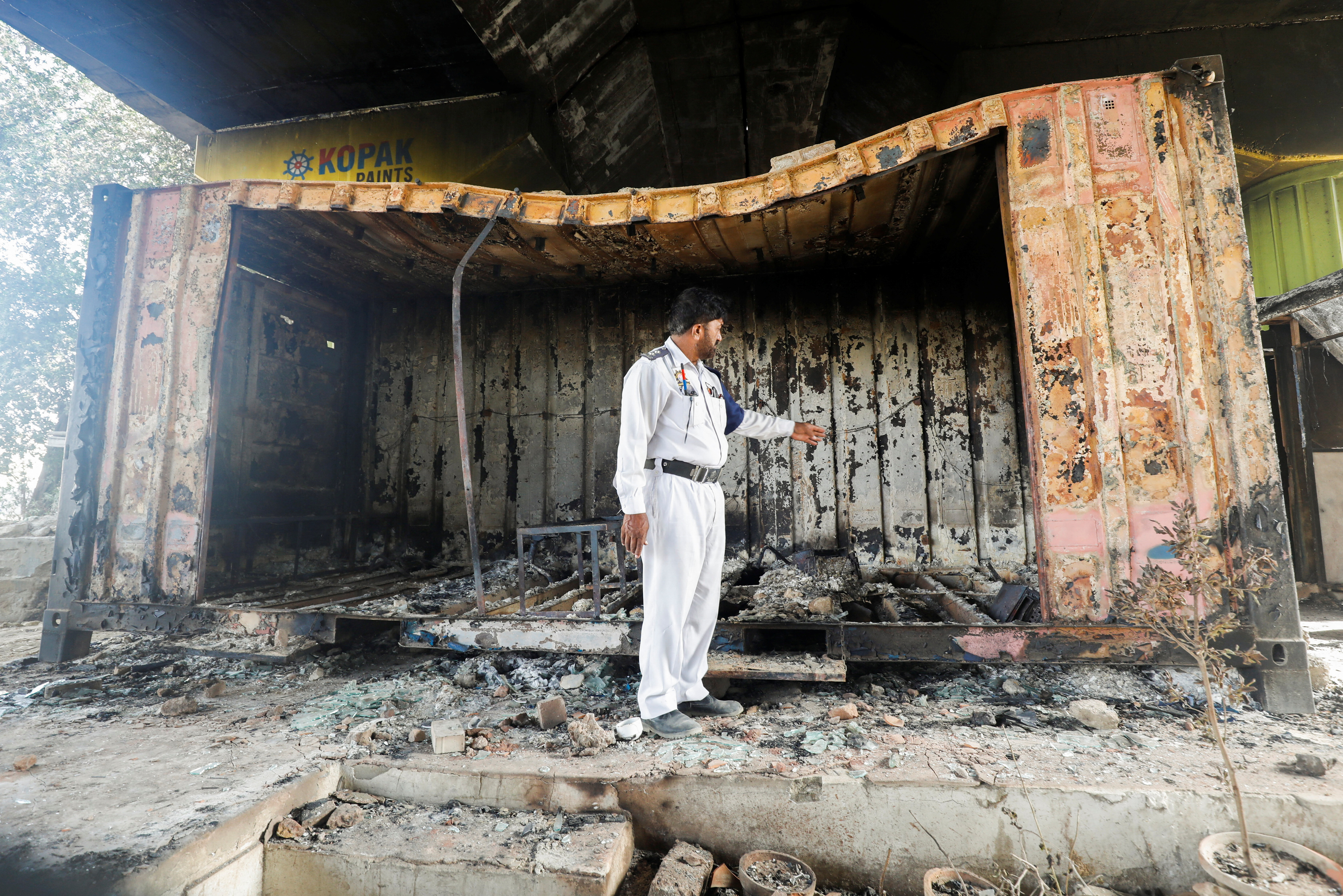 A traffic police officer walks amid damages of a check post, that was set afire by the supporters of Pakistan's former Prime Minister Imran Khan, during a protest against his arrest, in Karachi, Pakistan May 10, 2023. REUTERS/Akhtar Soomro